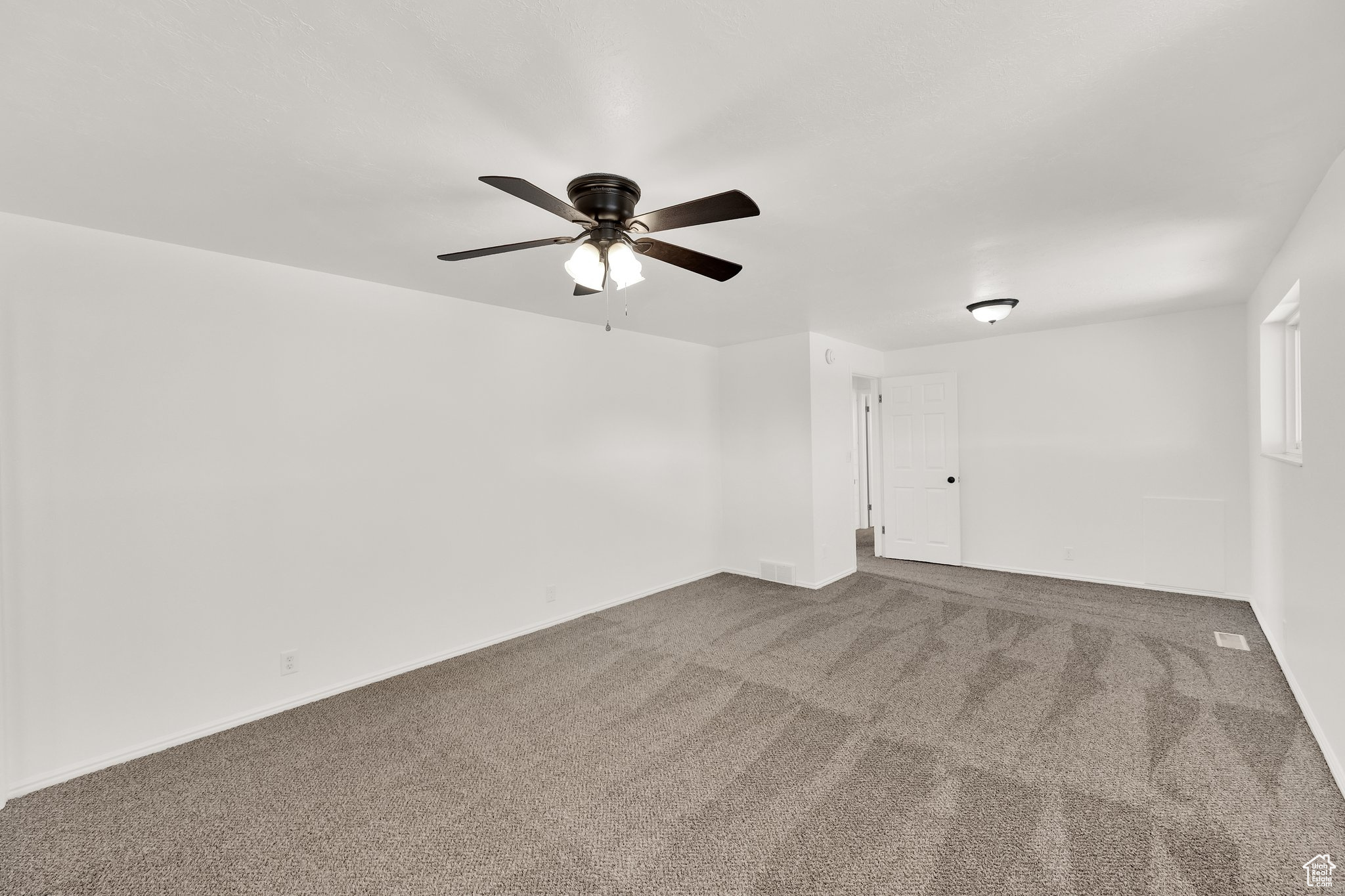 Empty room with carpet flooring and ceiling fan