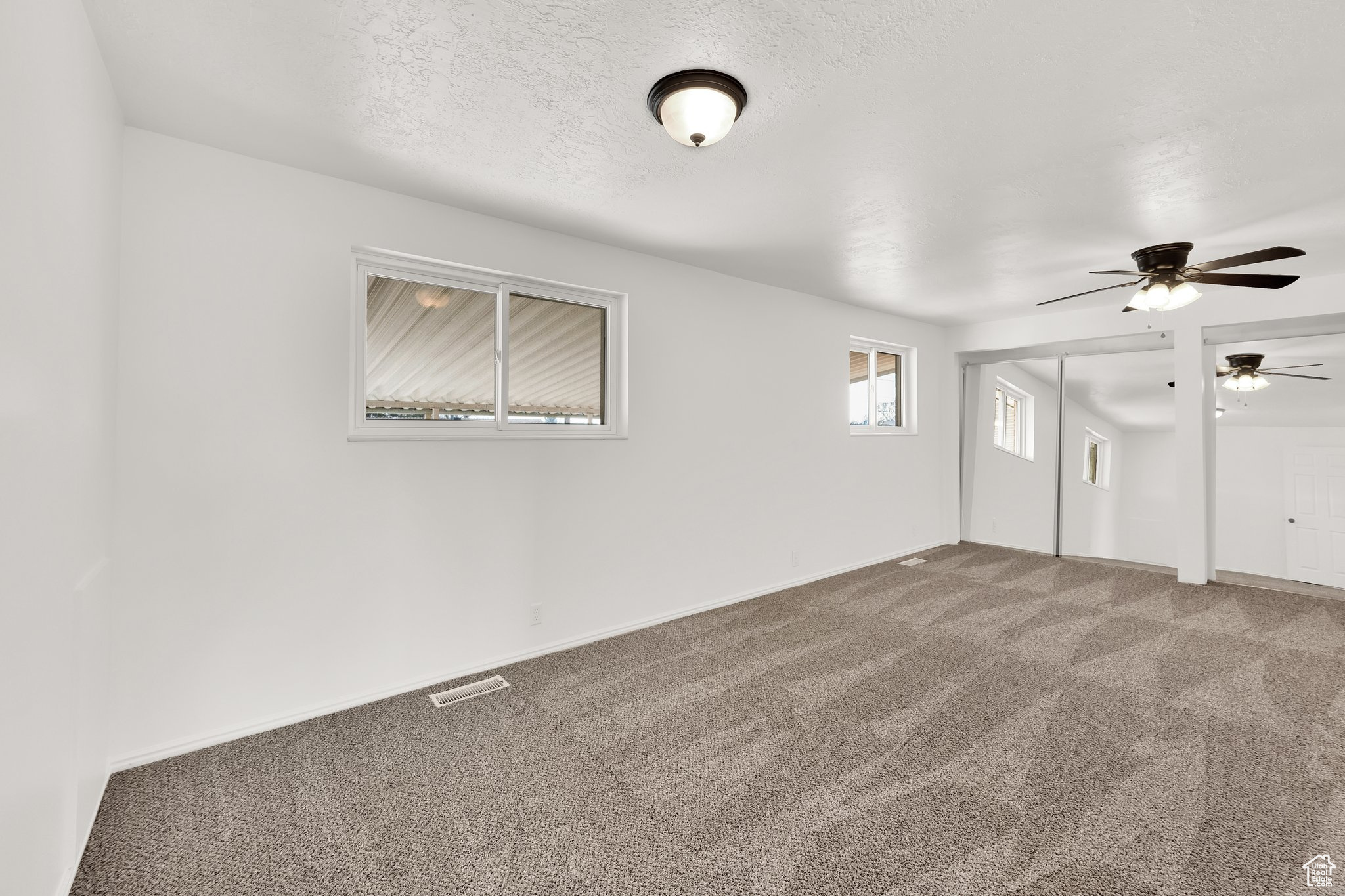 Carpeted spare room with a textured ceiling