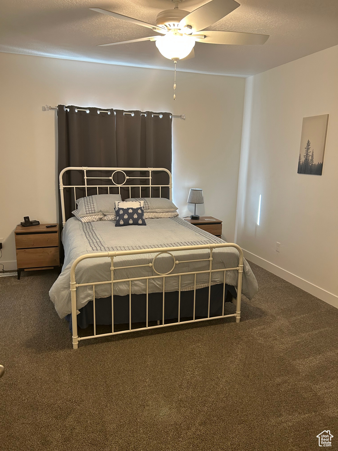 Carpeted bedroom featuring a textured ceiling and ceiling fan