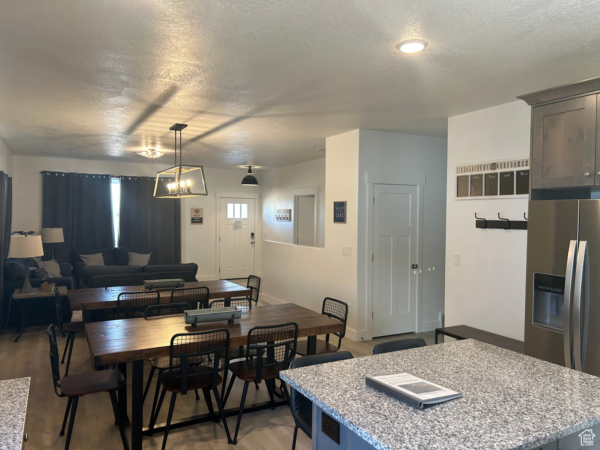 Dining room featuring a notable chandelier, light hardwood / wood-style flooring, and a textured ceiling