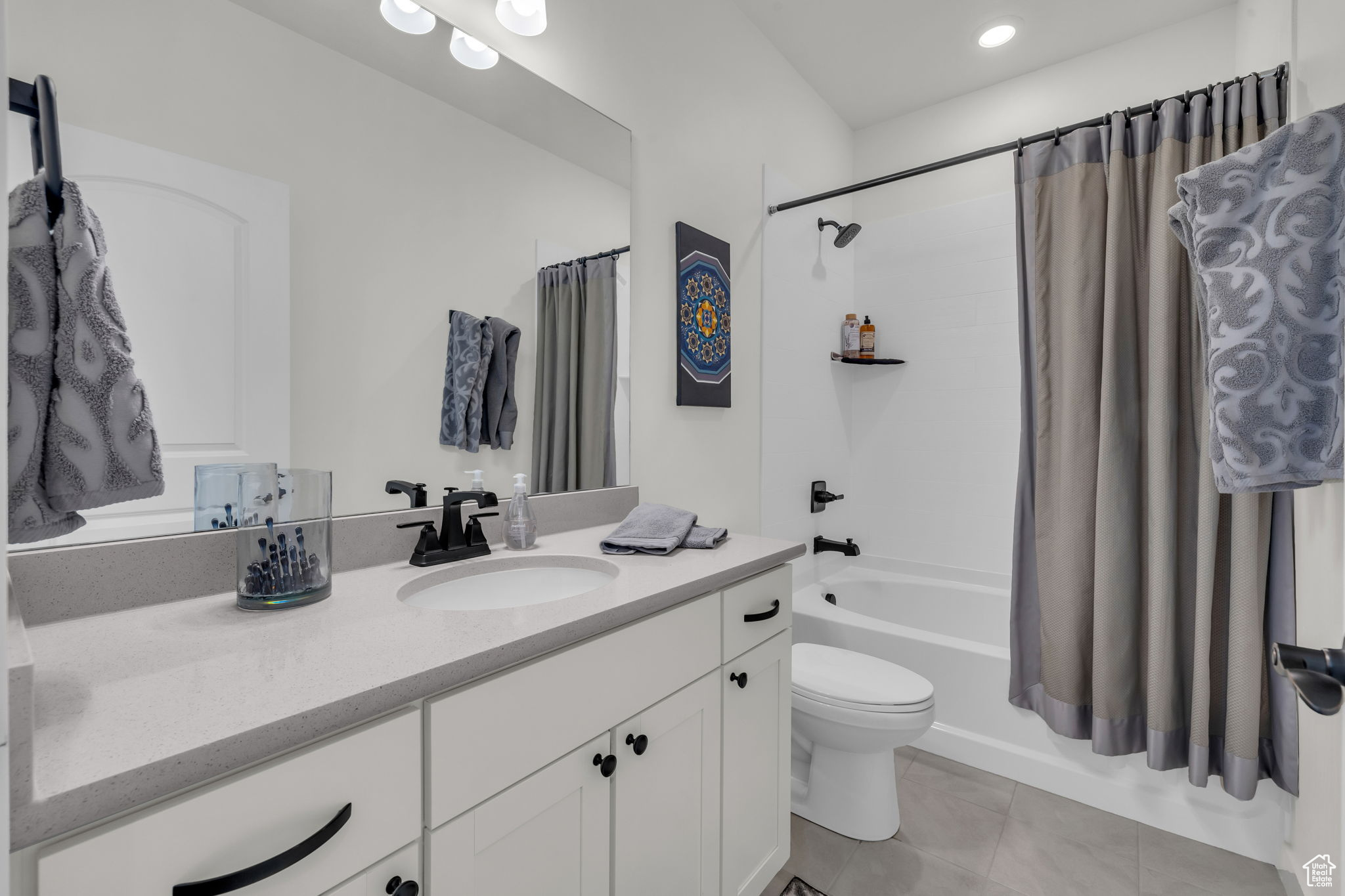 Full bathroom with shower / tub combo, vanity, tile patterned floors, and toilet