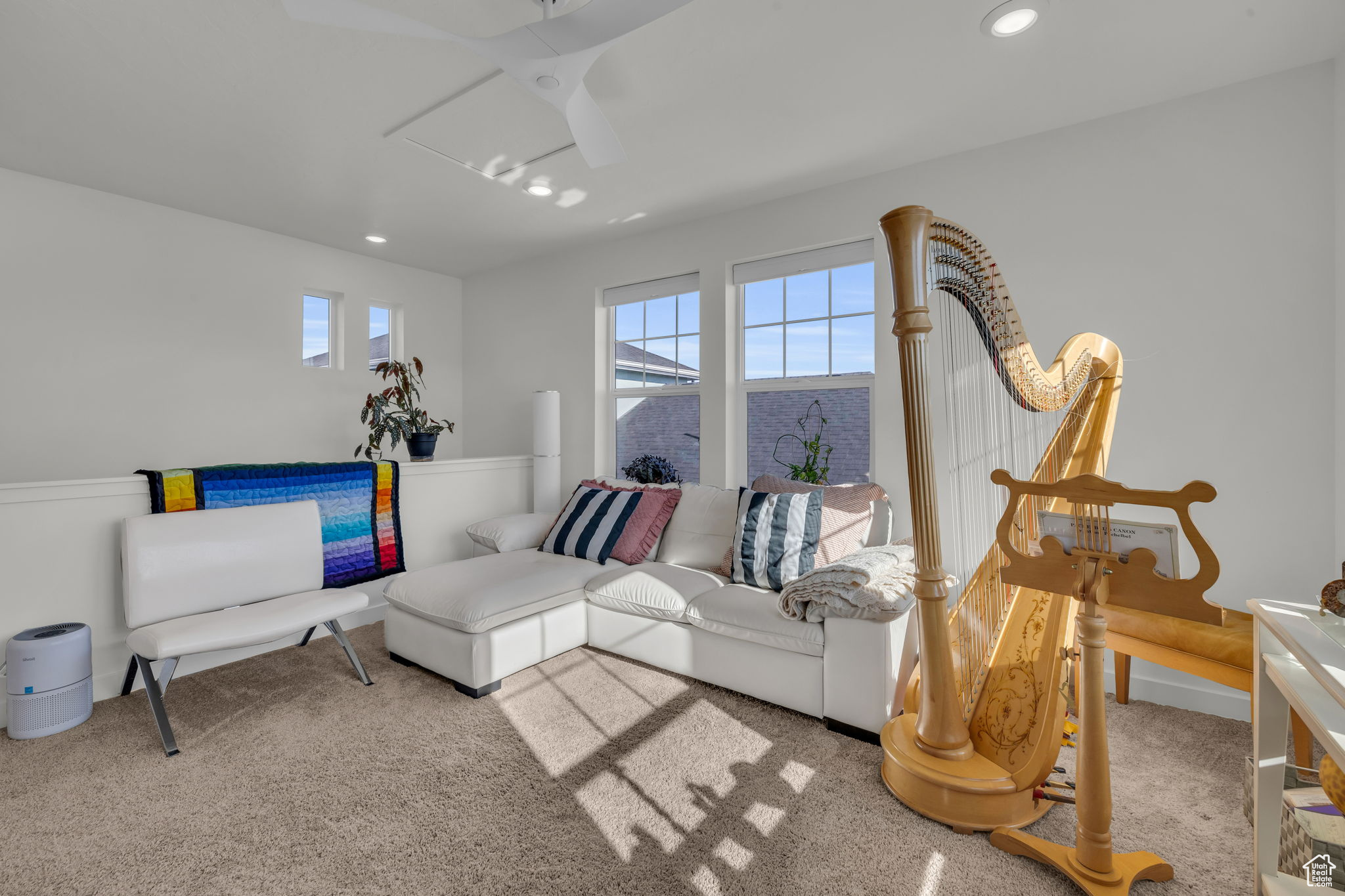 Living room with a wealth of natural light and light colored carpet
