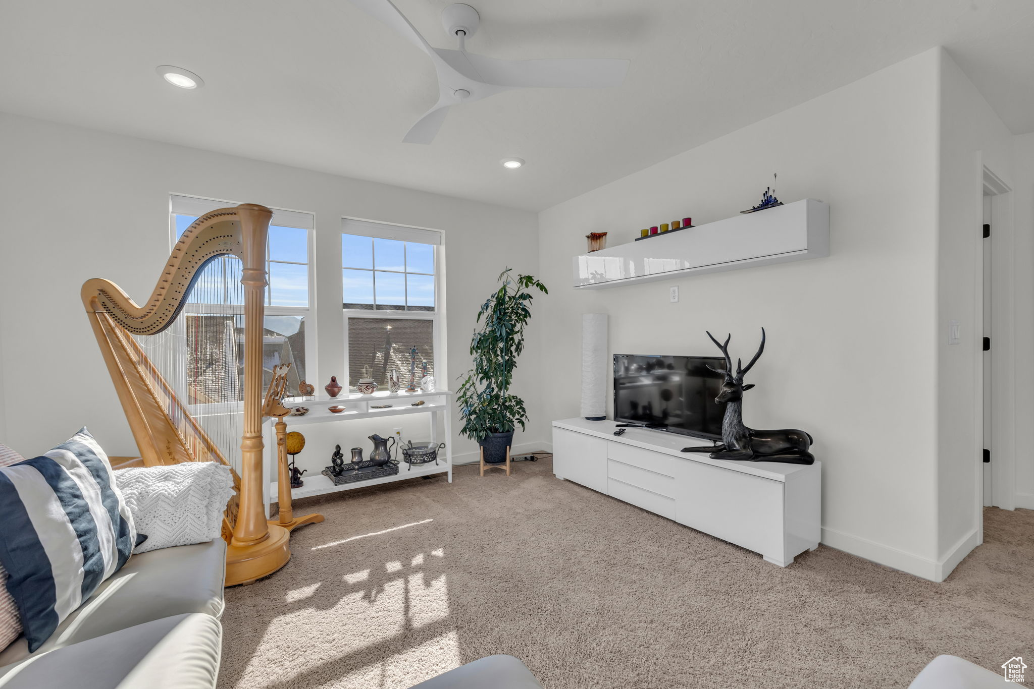 Carpeted living room featuring ceiling fan