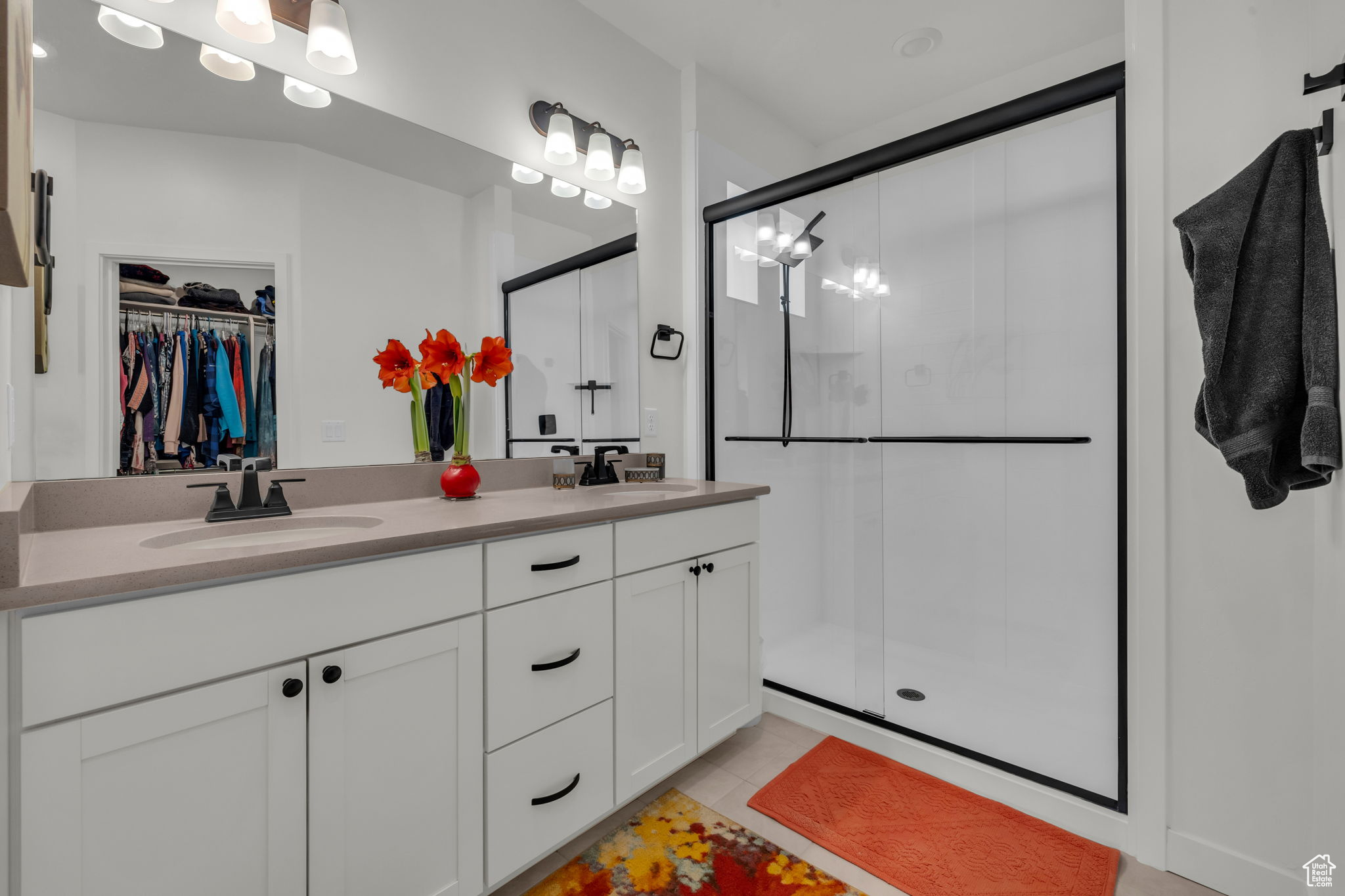 Bathroom featuring tile patterned flooring, vanity, and a shower with shower door