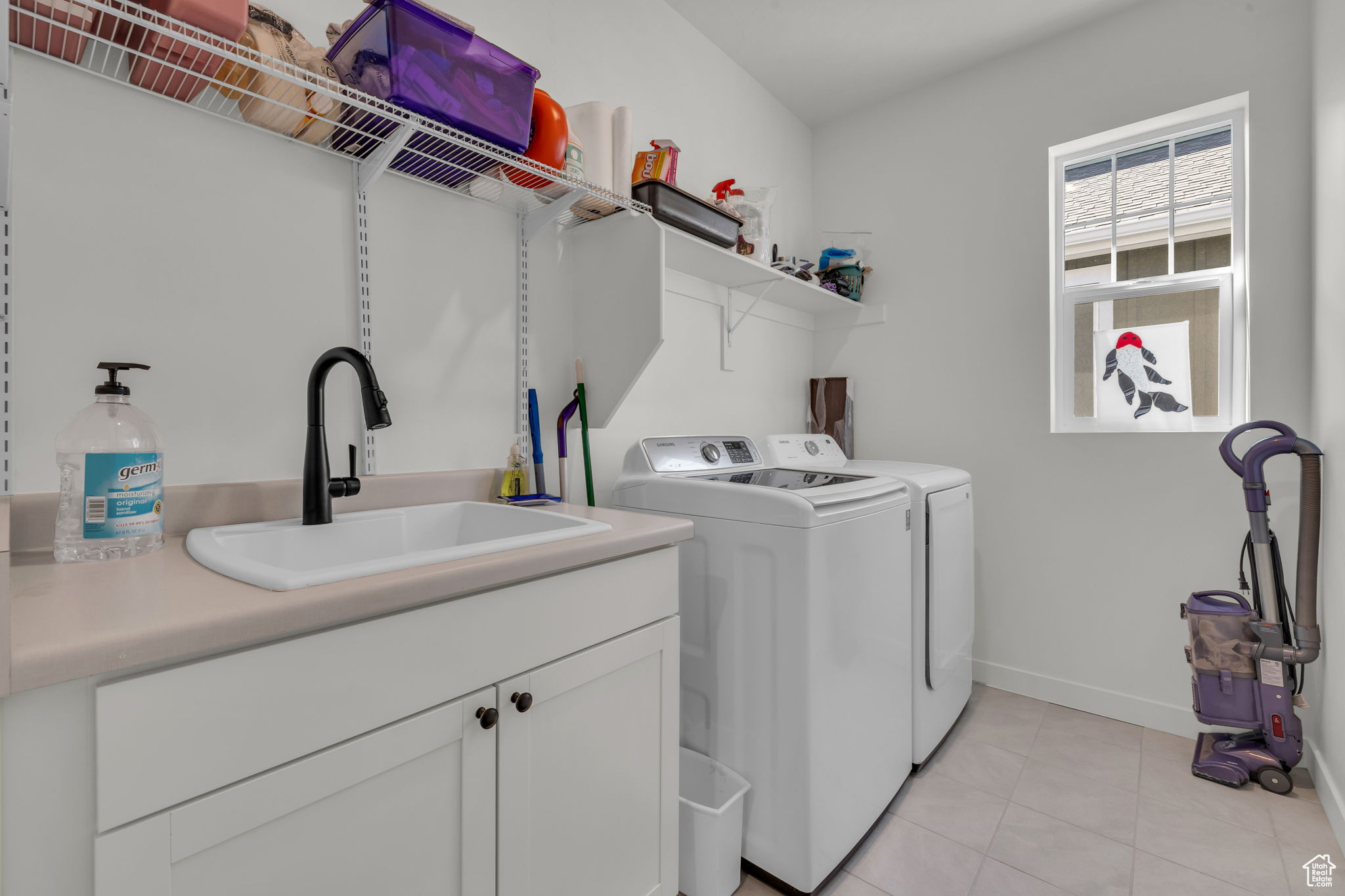 Laundry area featuring cabinets, washing machine and dryer, sink, and light tile patterned floors