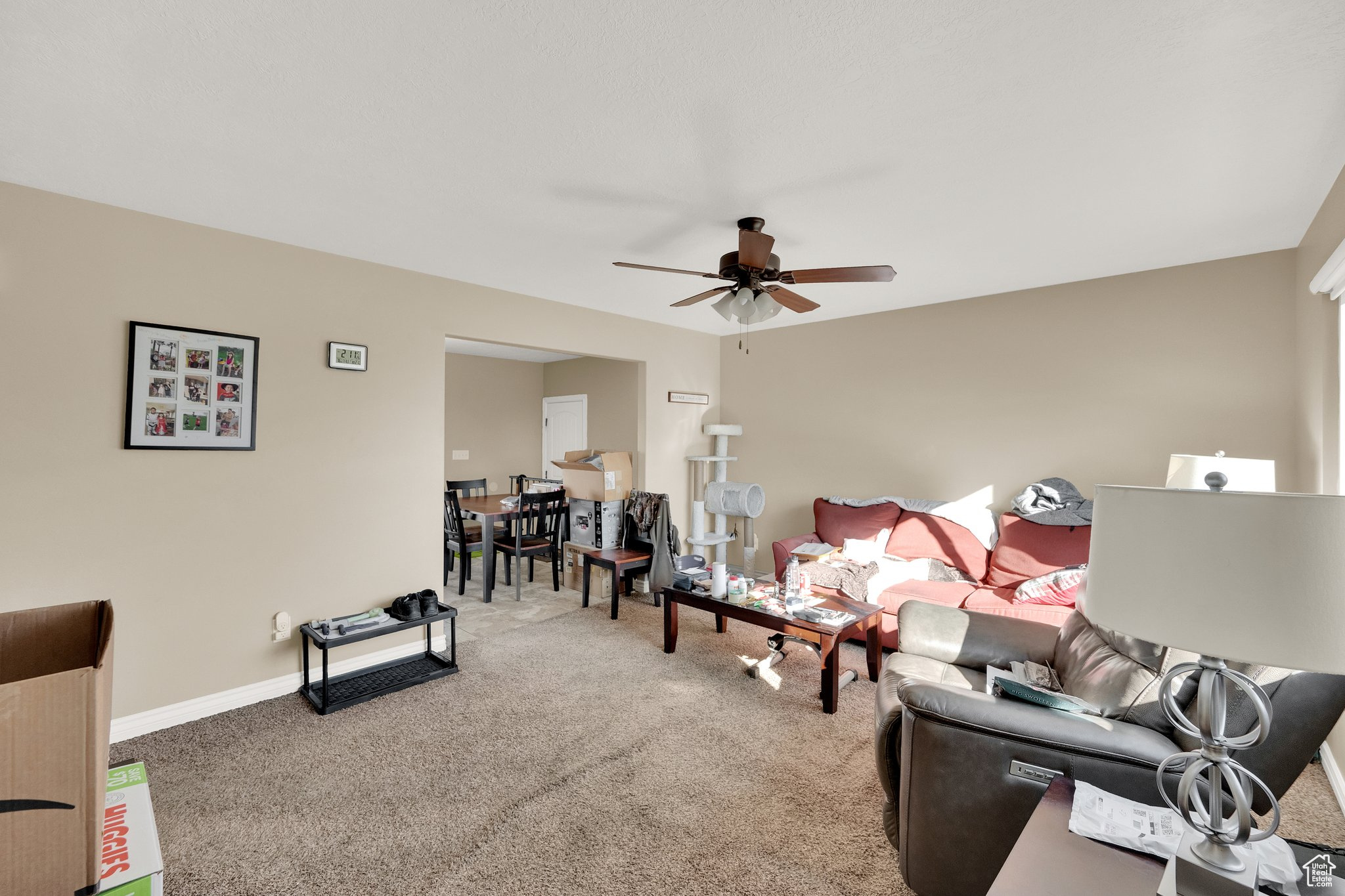 Carpeted living room featuring ceiling fan