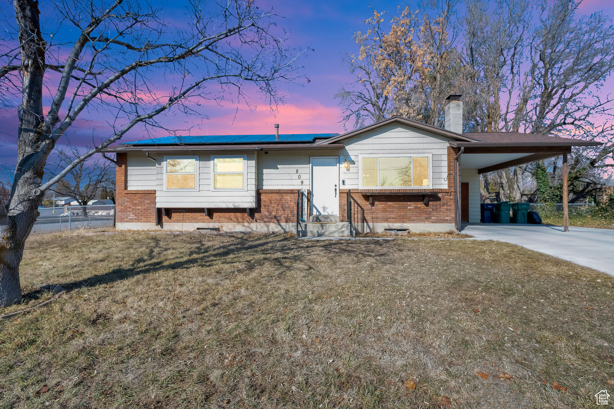 View of front of home with a lawn and a carport