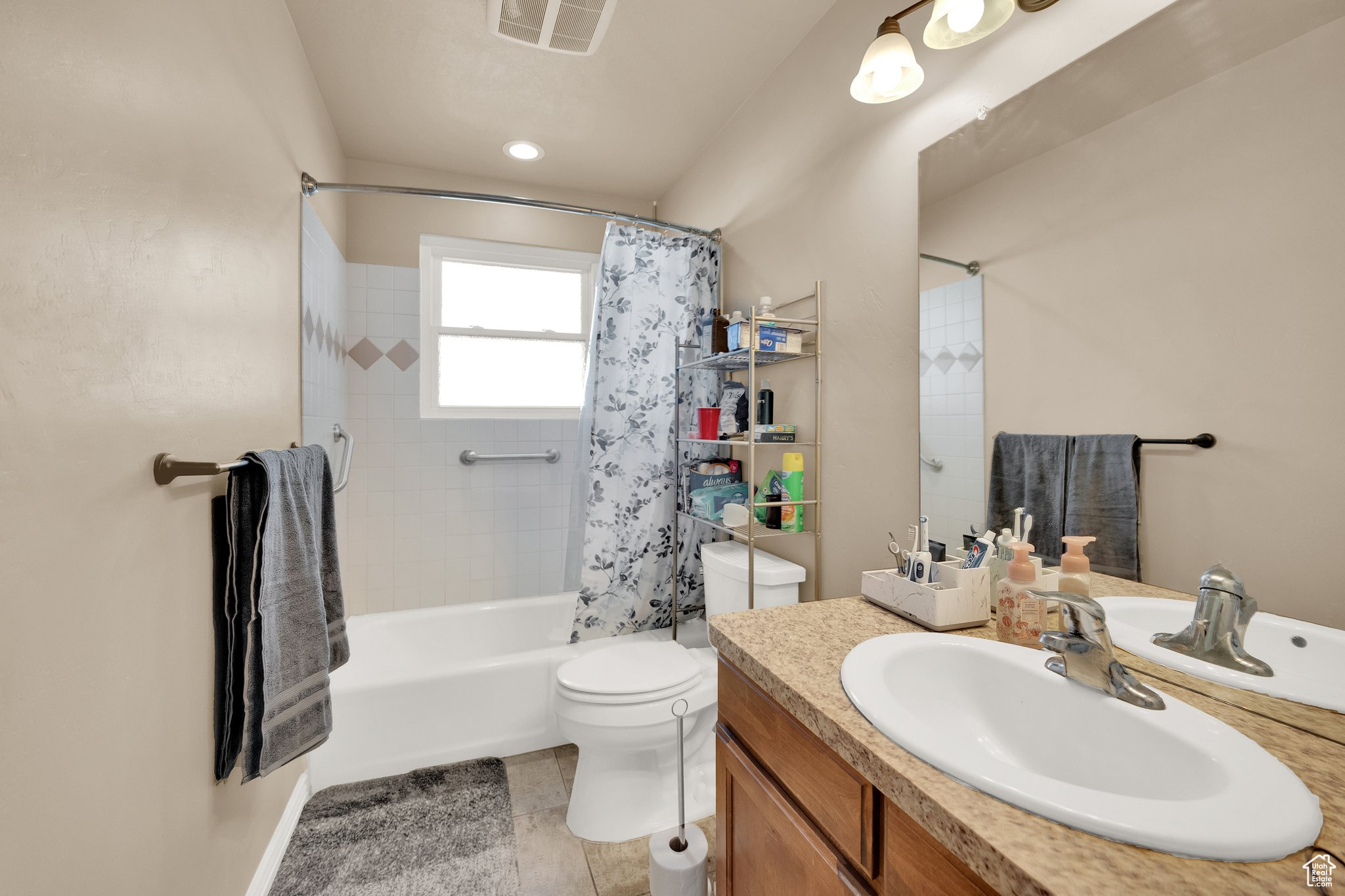 Full bathroom with tile patterned flooring, vanity, shower / bath combo with shower curtain, and toilet