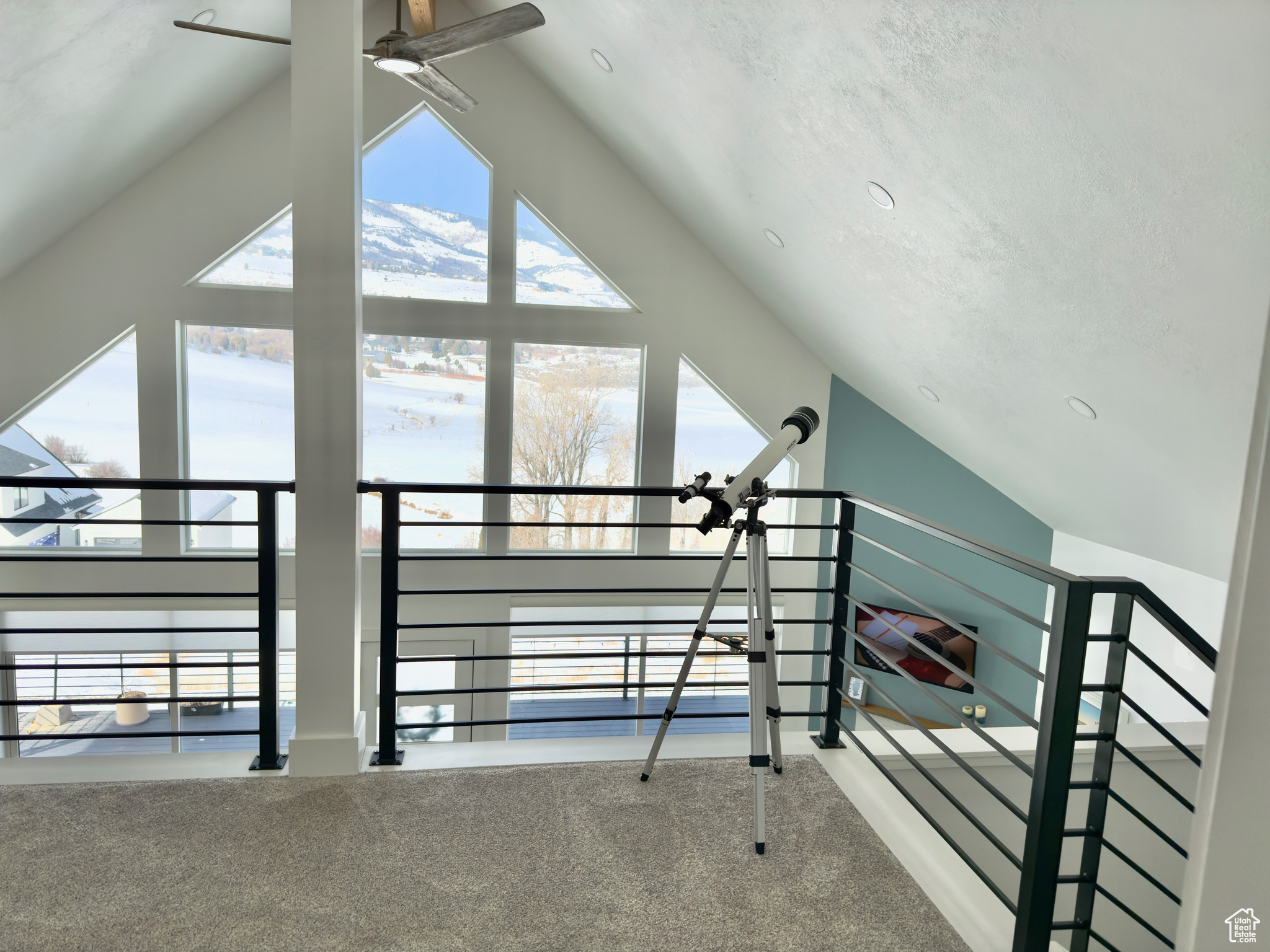 Stairway with lofted ceiling, carpet floors, and ceiling fan