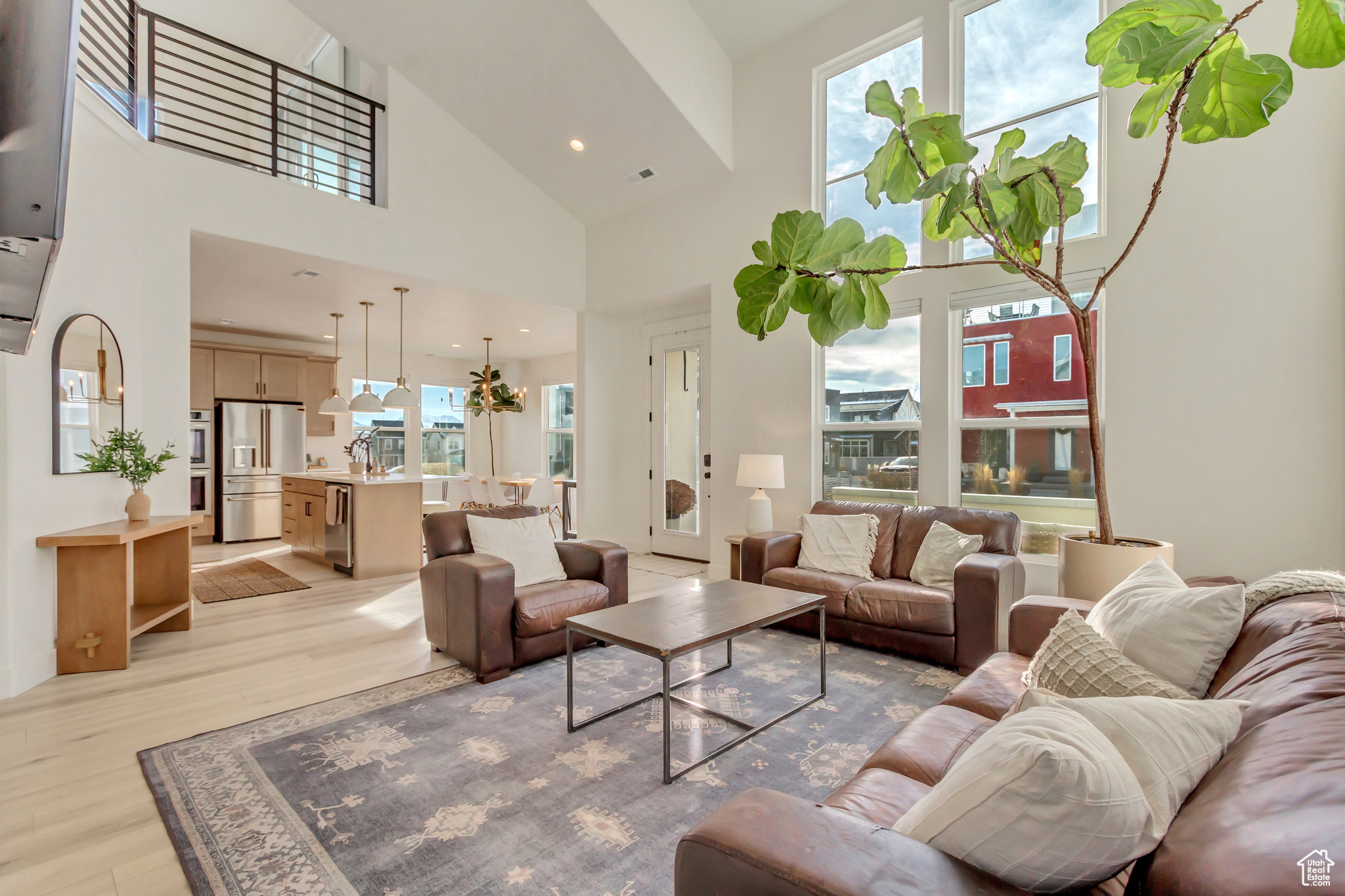 Living room with a high ceiling and light wood-type flooring