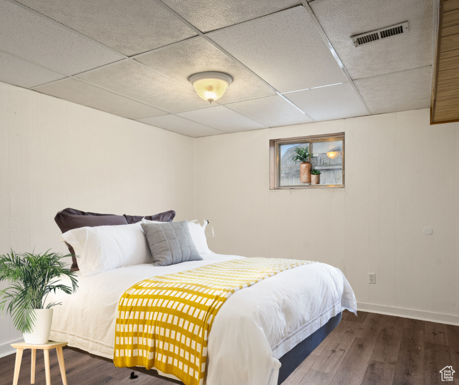 Virtually staged bedroom featuring wood-type flooring.