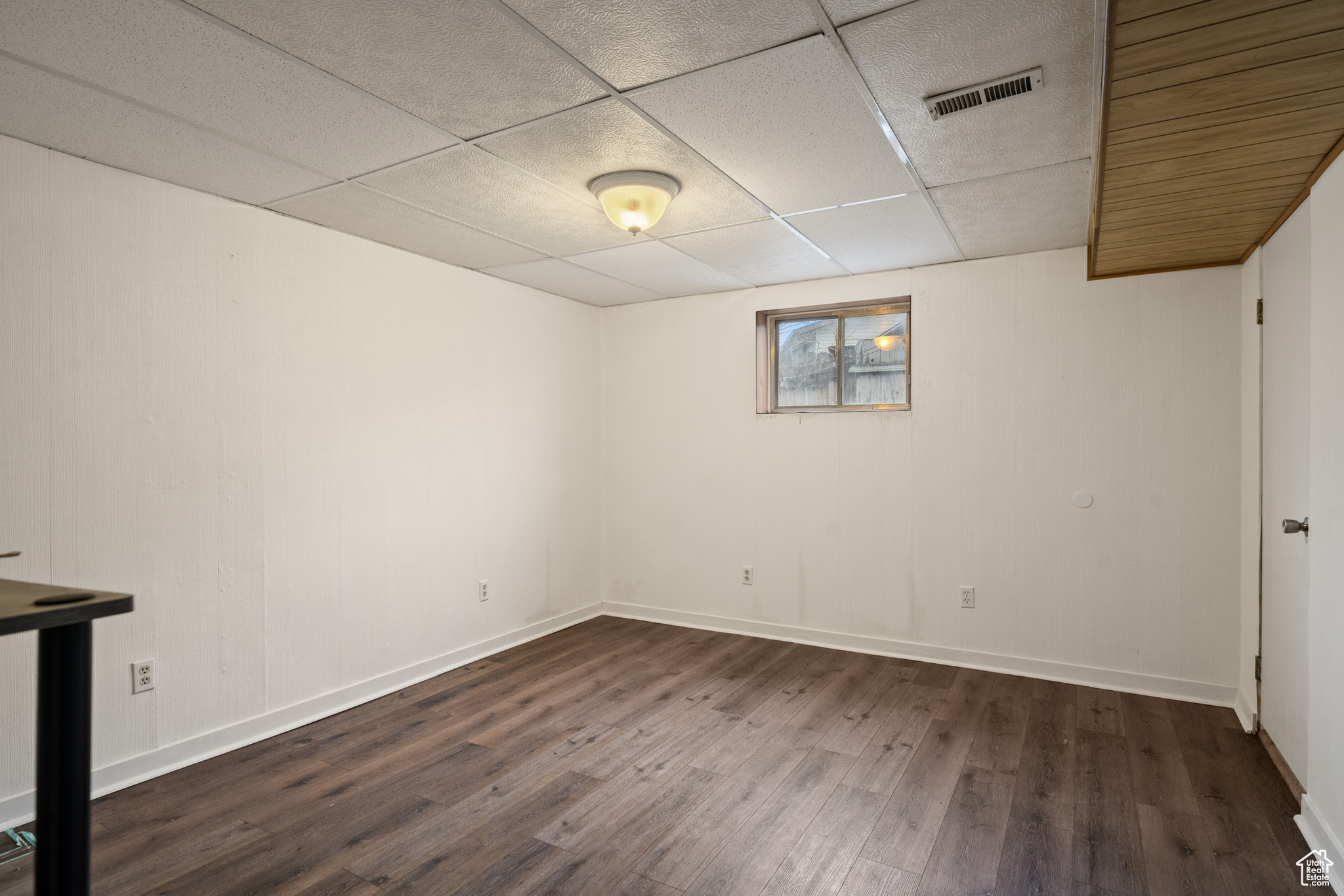 Basement bedroom with wood-style floors.