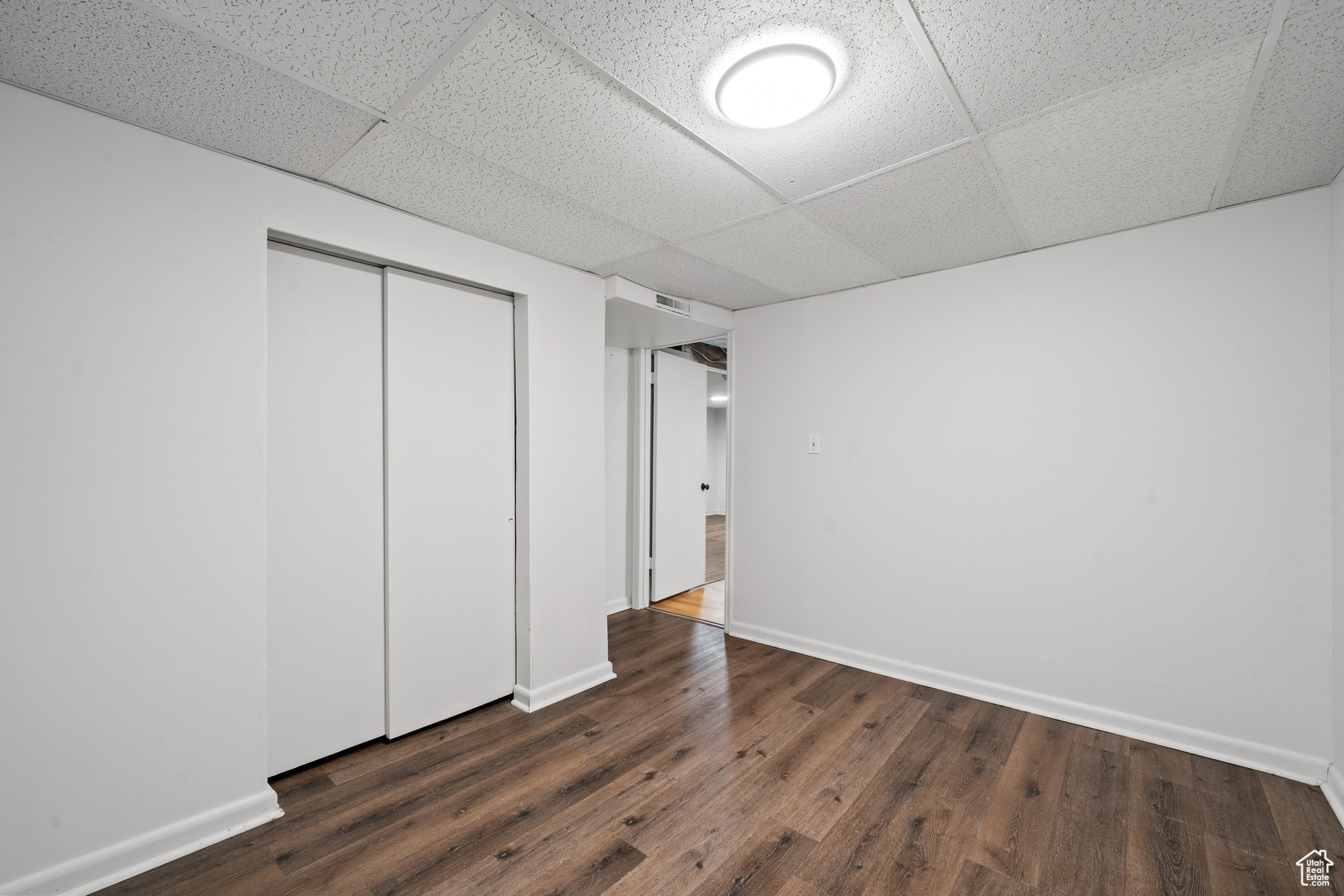 Unfurnished bedroom with wood-style floors and a closet.