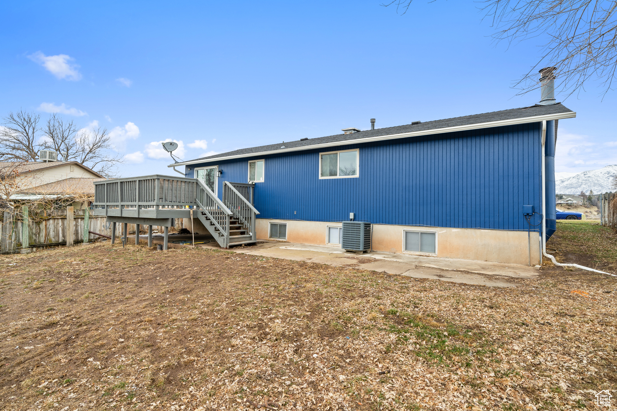 Rear view of property with a deck with mountain view, central AC unit, and a patio area