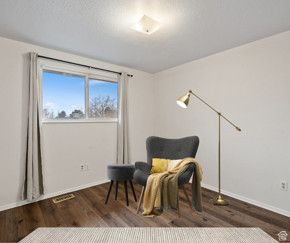 Virtually staged bedroom with wood-type flooring.