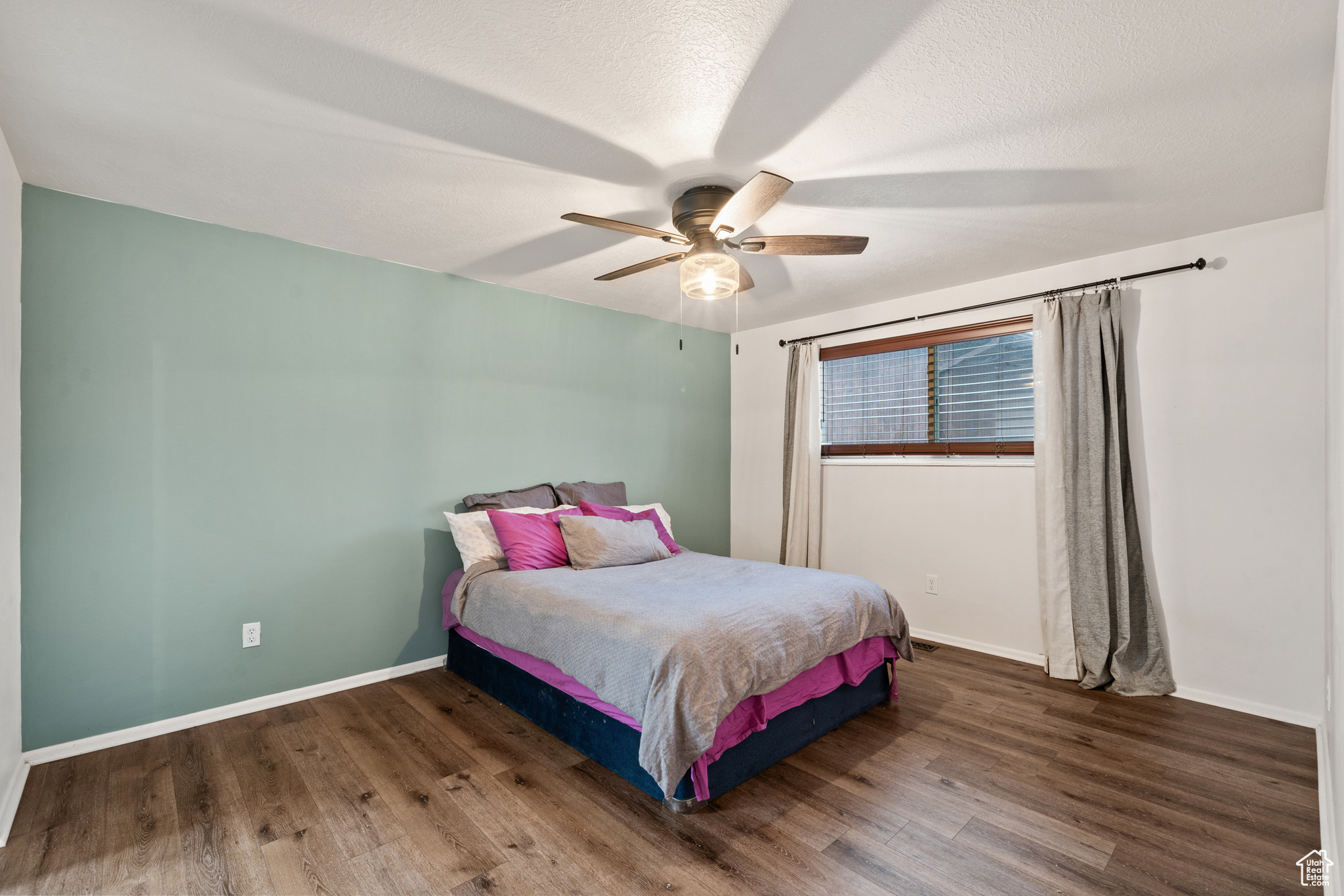 Bedroom with wood-type flooring, a textured ceiling, and ceiling fan