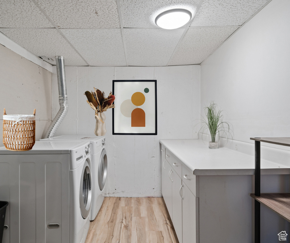 Laundry room featuring cabinets, light hardwood / wood-style floors, and independent washer and dryer