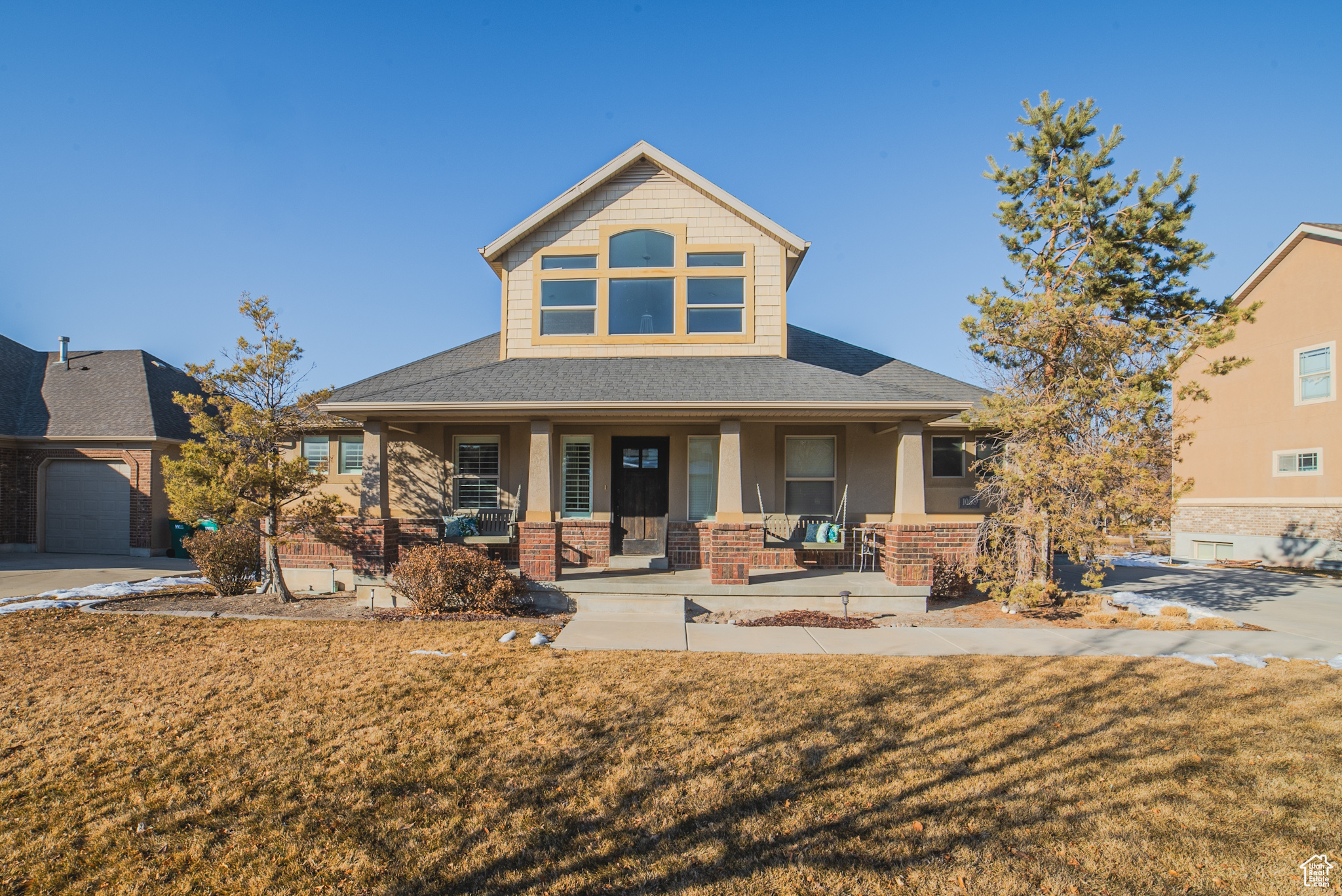 View of front of house featuring a garage, a front yard, and a porch