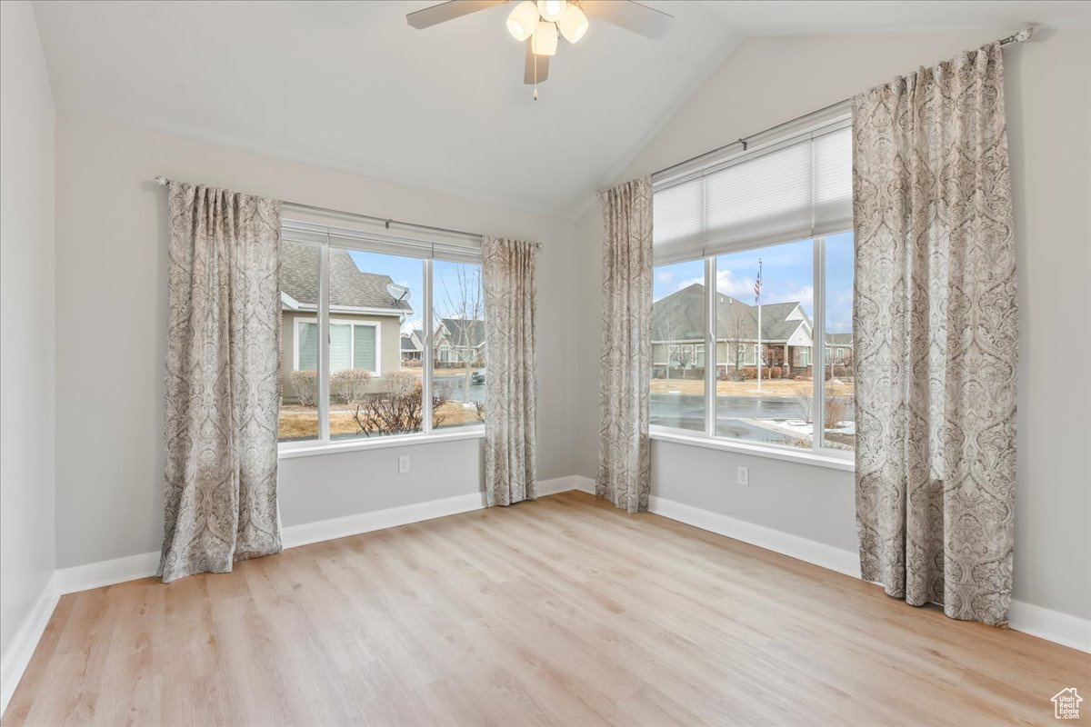 Unfurnished room featuring ceiling fan, vaulted ceiling, and light hardwood / wood-style flooring