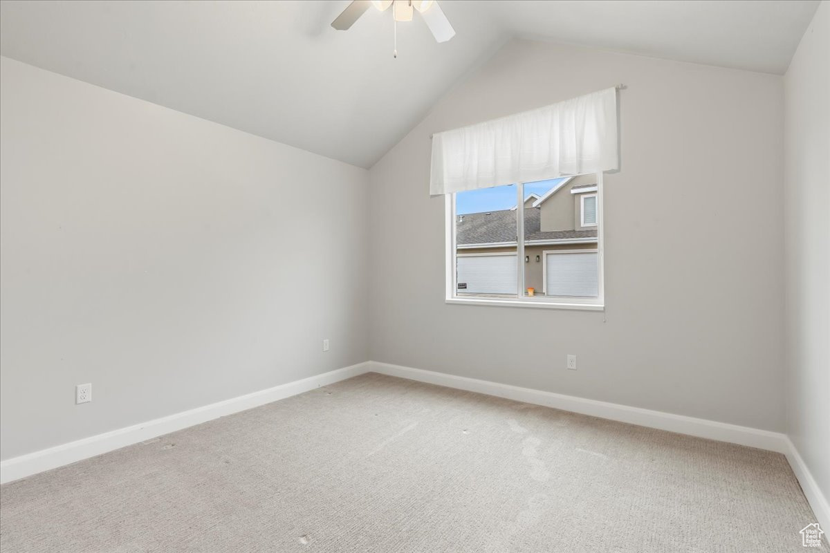 Bonus room with vaulted ceiling, carpet floors, and ceiling fan