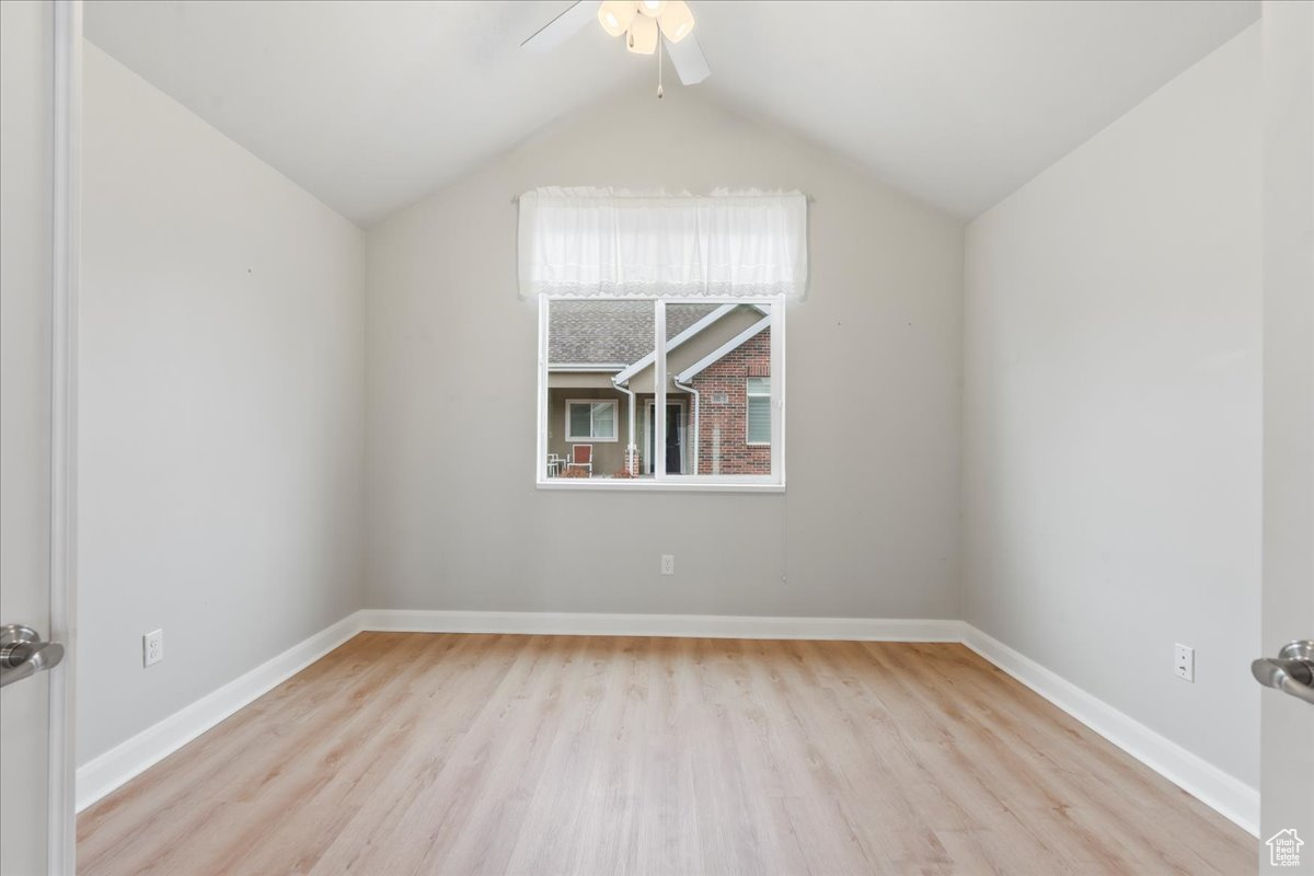 Additional living space with ceiling fan, lofted ceiling, and light hardwood / wood-style floors