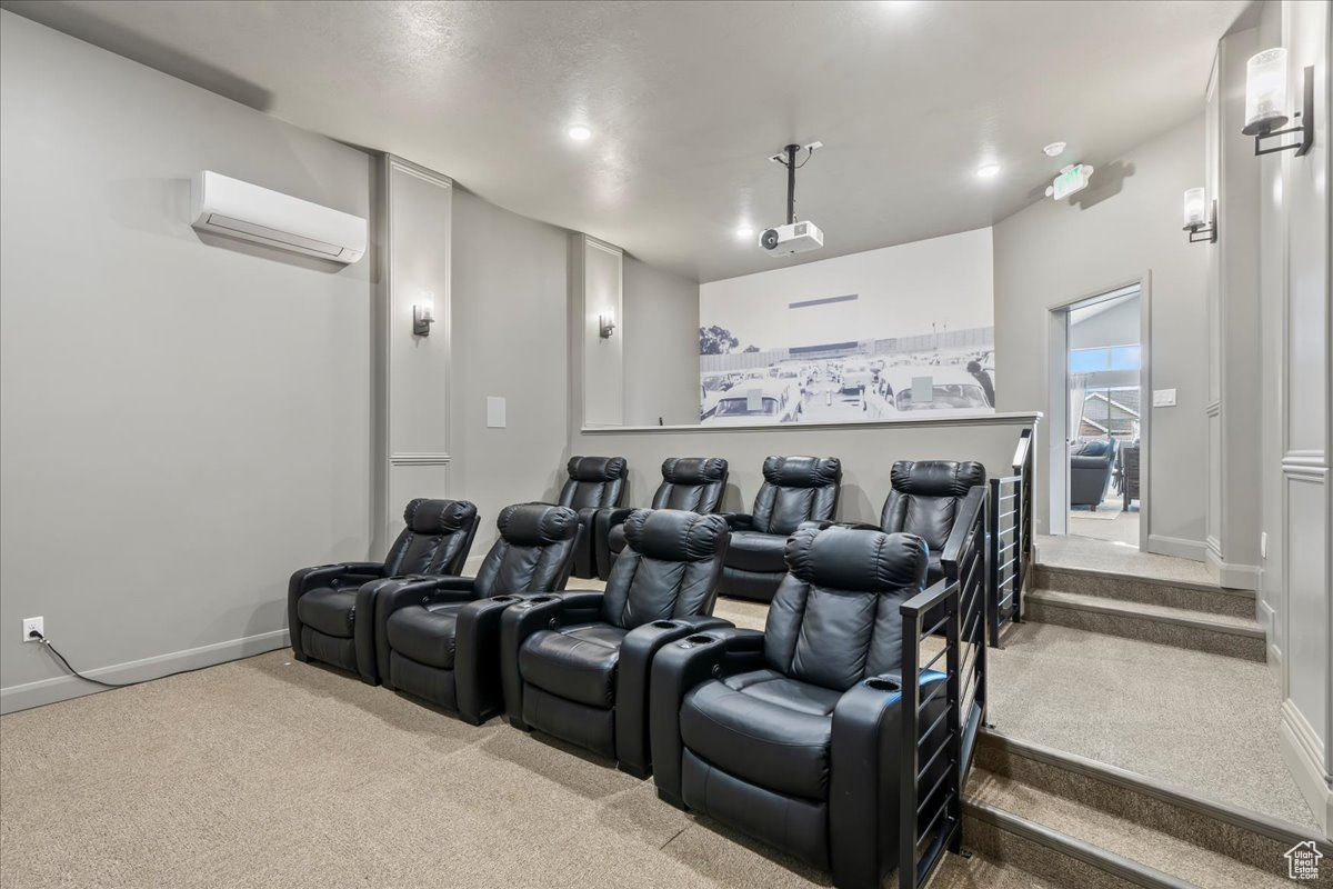 Home theater featuring a wall mounted air conditioner and carpet