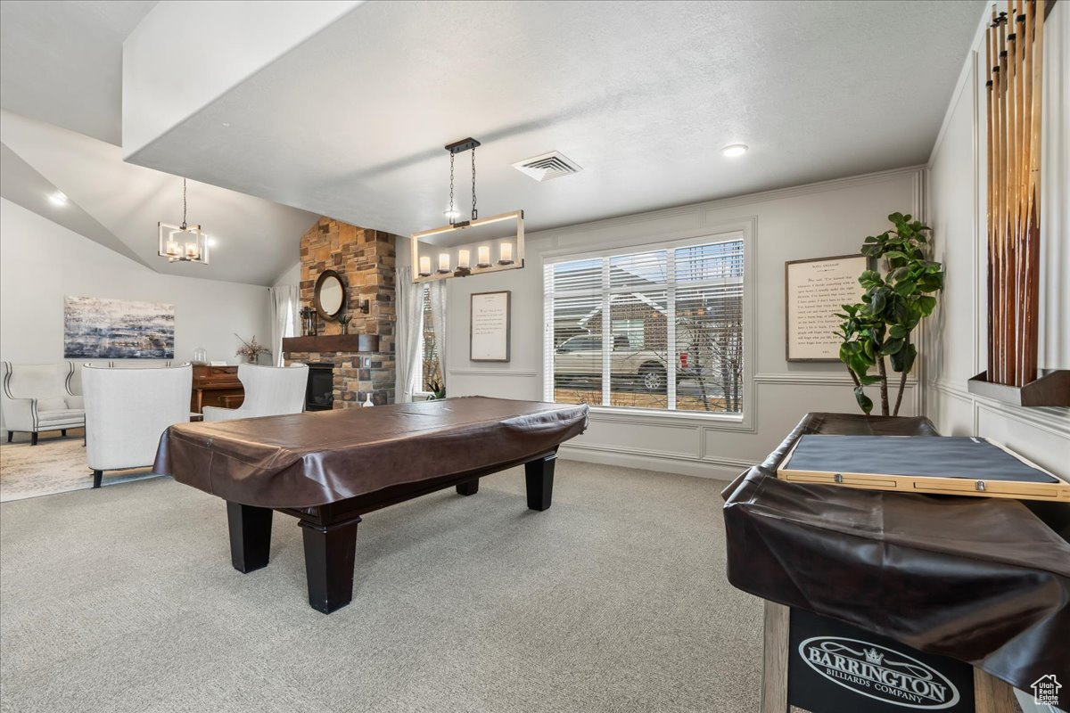 Playroom with lofted ceiling, a stone fireplace, pool table, and carpet flooring