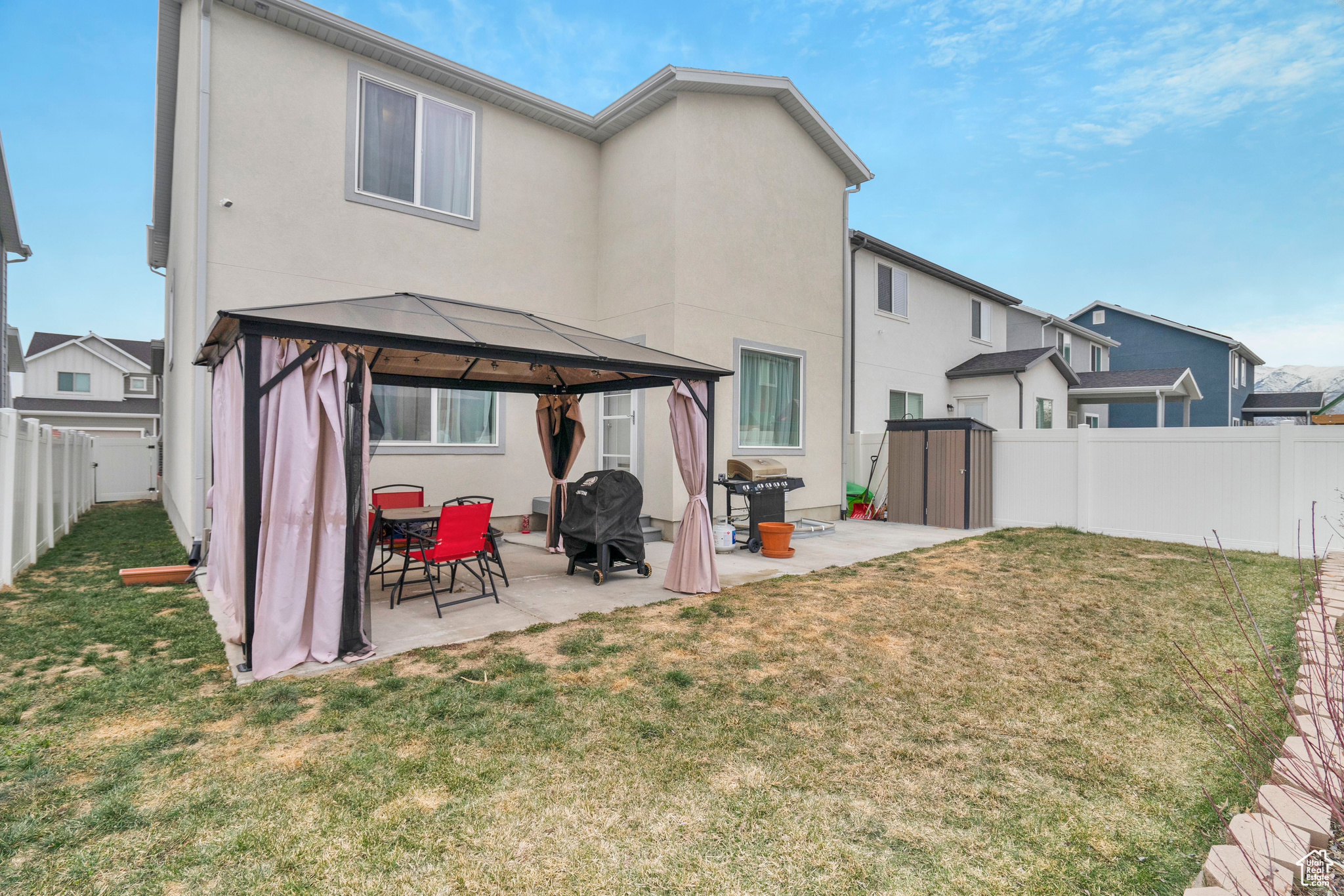 Back of house featuring a gazebo, patio and fully landscaped & fenced.