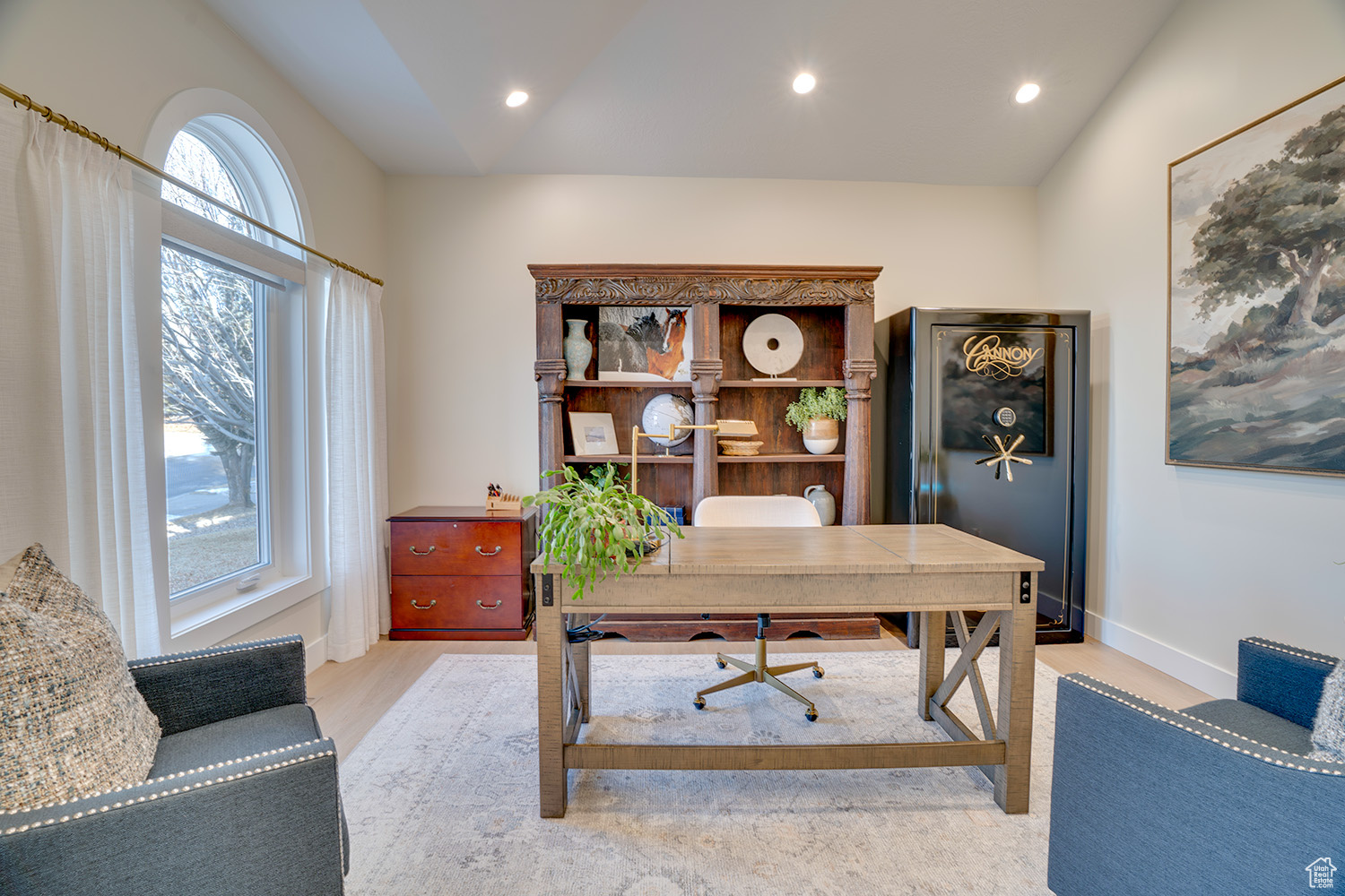 Office space with lofted ceiling and light hardwood / wood-style floors