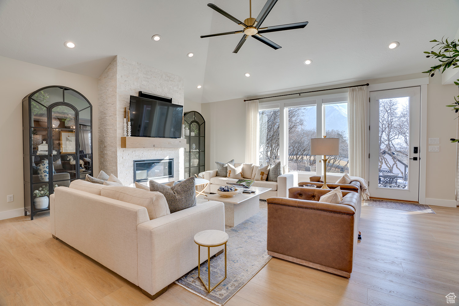 Living room with light hardwood / wood-style flooring, a fireplace, and high vaulted ceiling