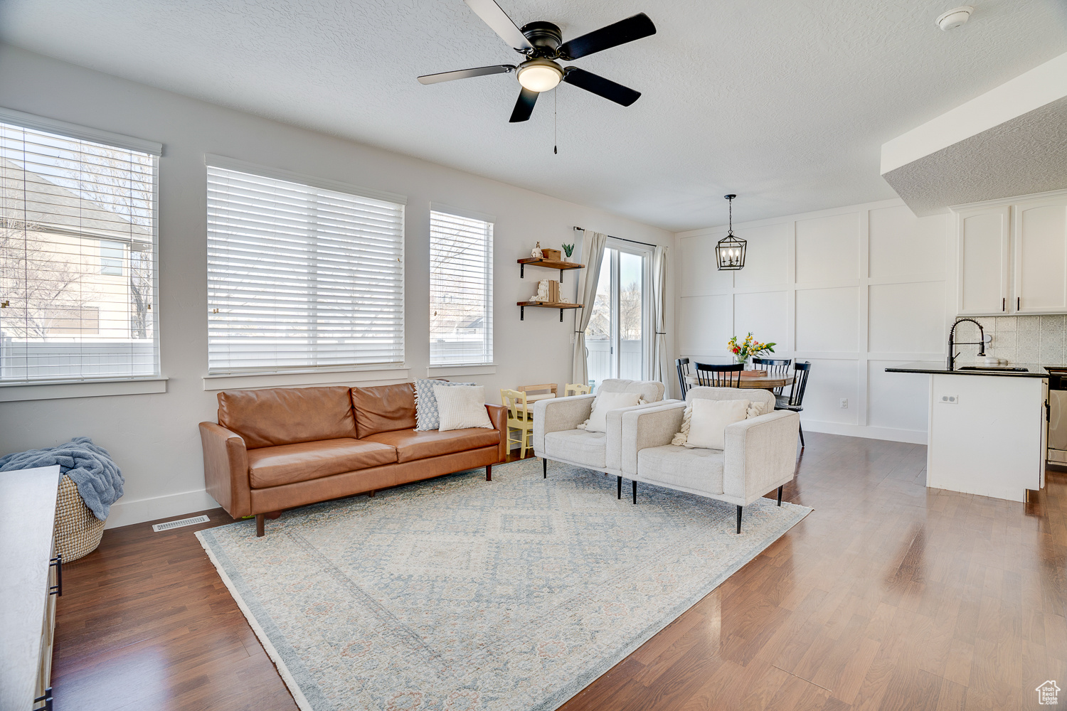 Living room with ceiling fan, dark hardwood / wood-style floors, and a textured ceiling