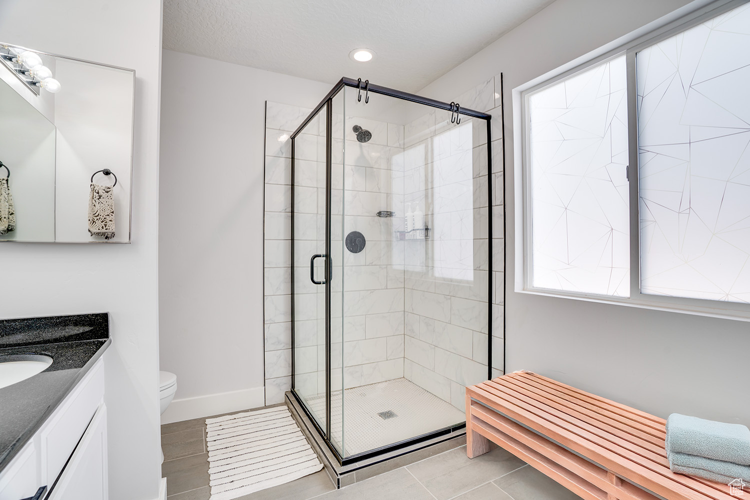 Bathroom with vanity, an enclosed shower, and toilet