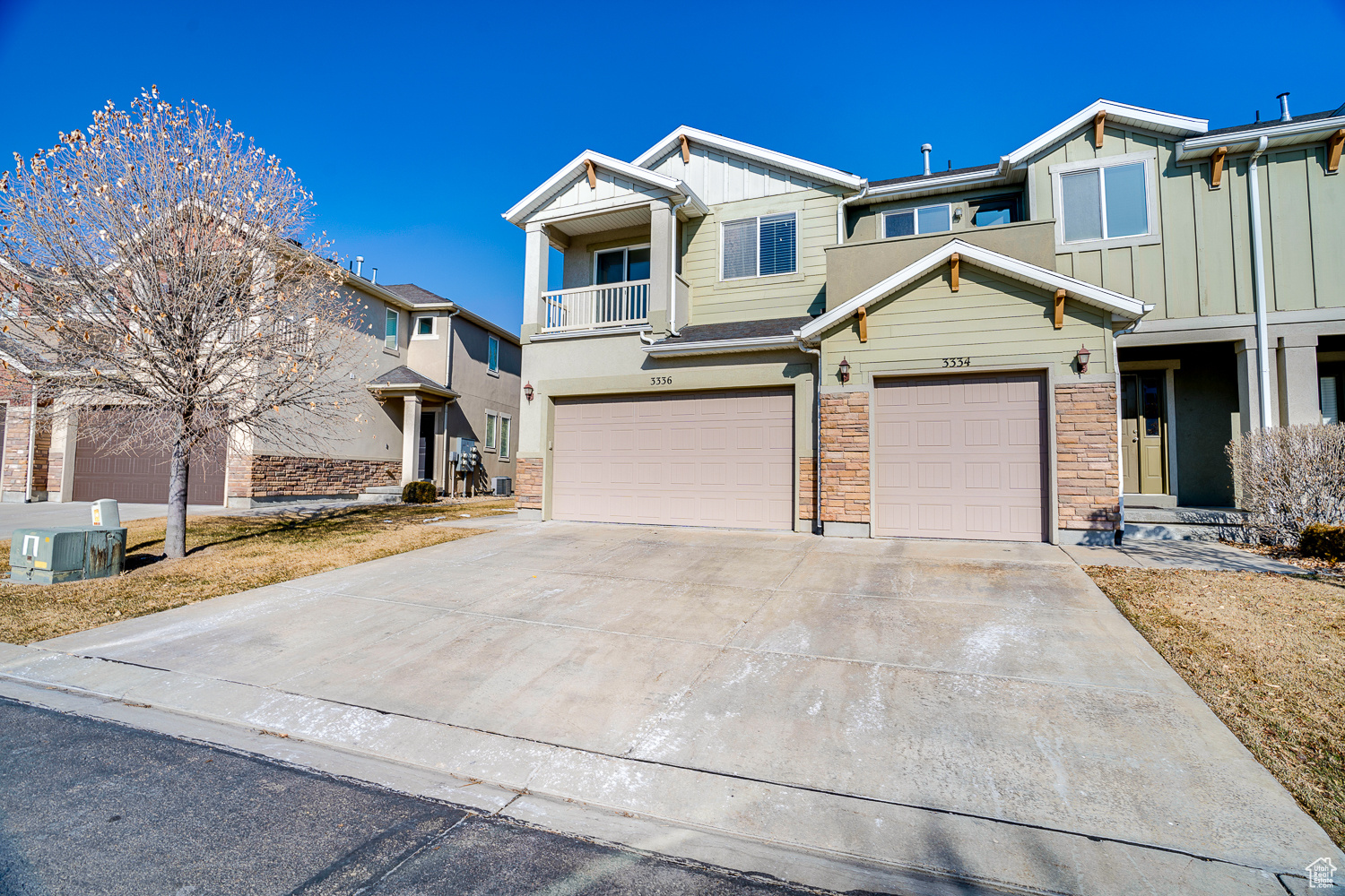 View of front of property featuring a garage and a balcony