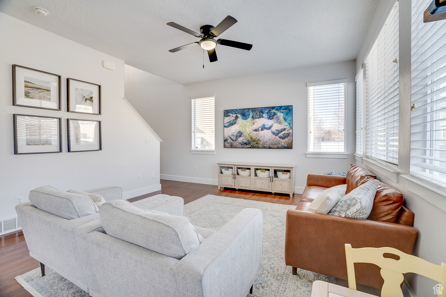 Living room with dark wood-type flooring and ceiling fan