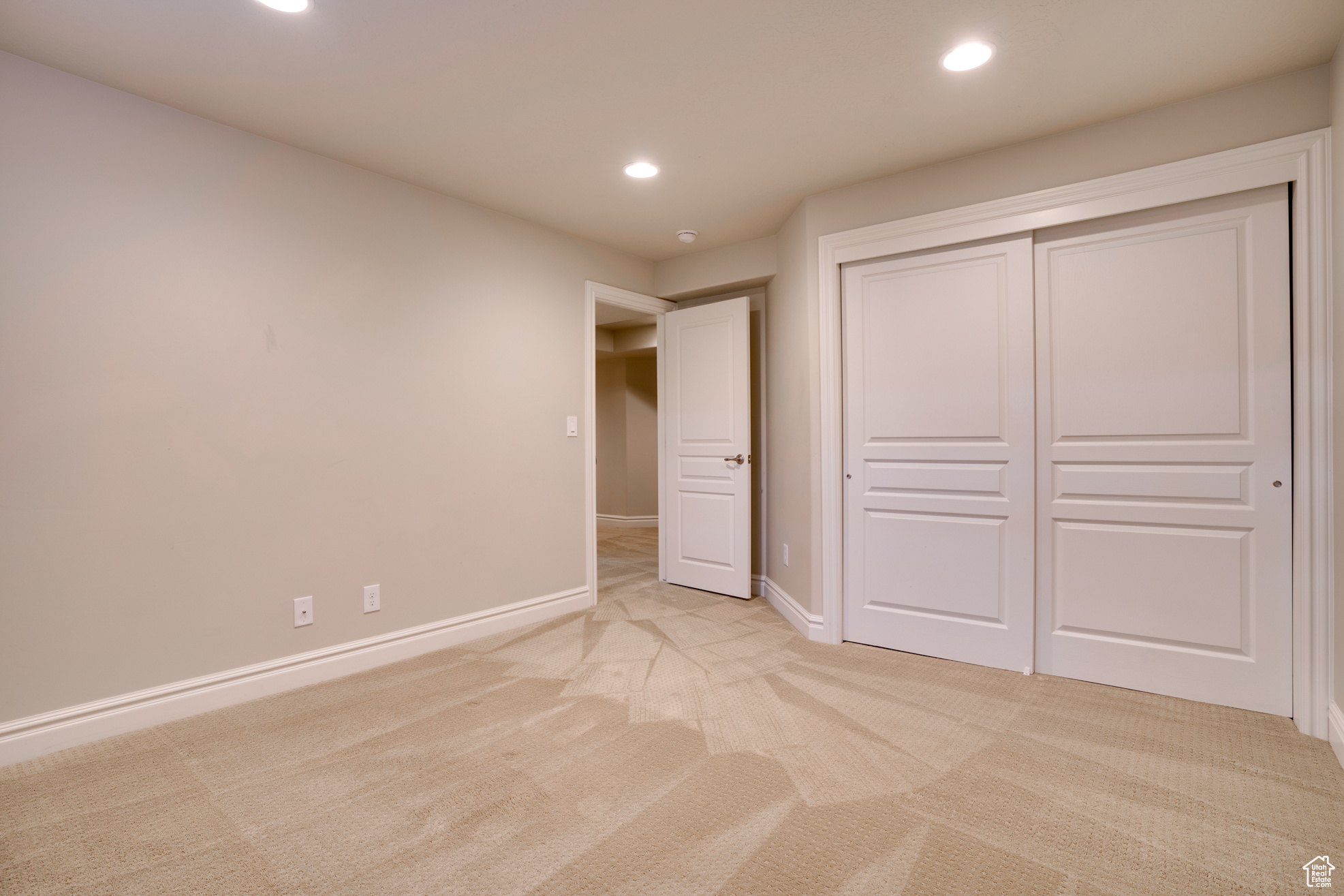 Unfurnished bedroom featuring light colored carpet and a closet