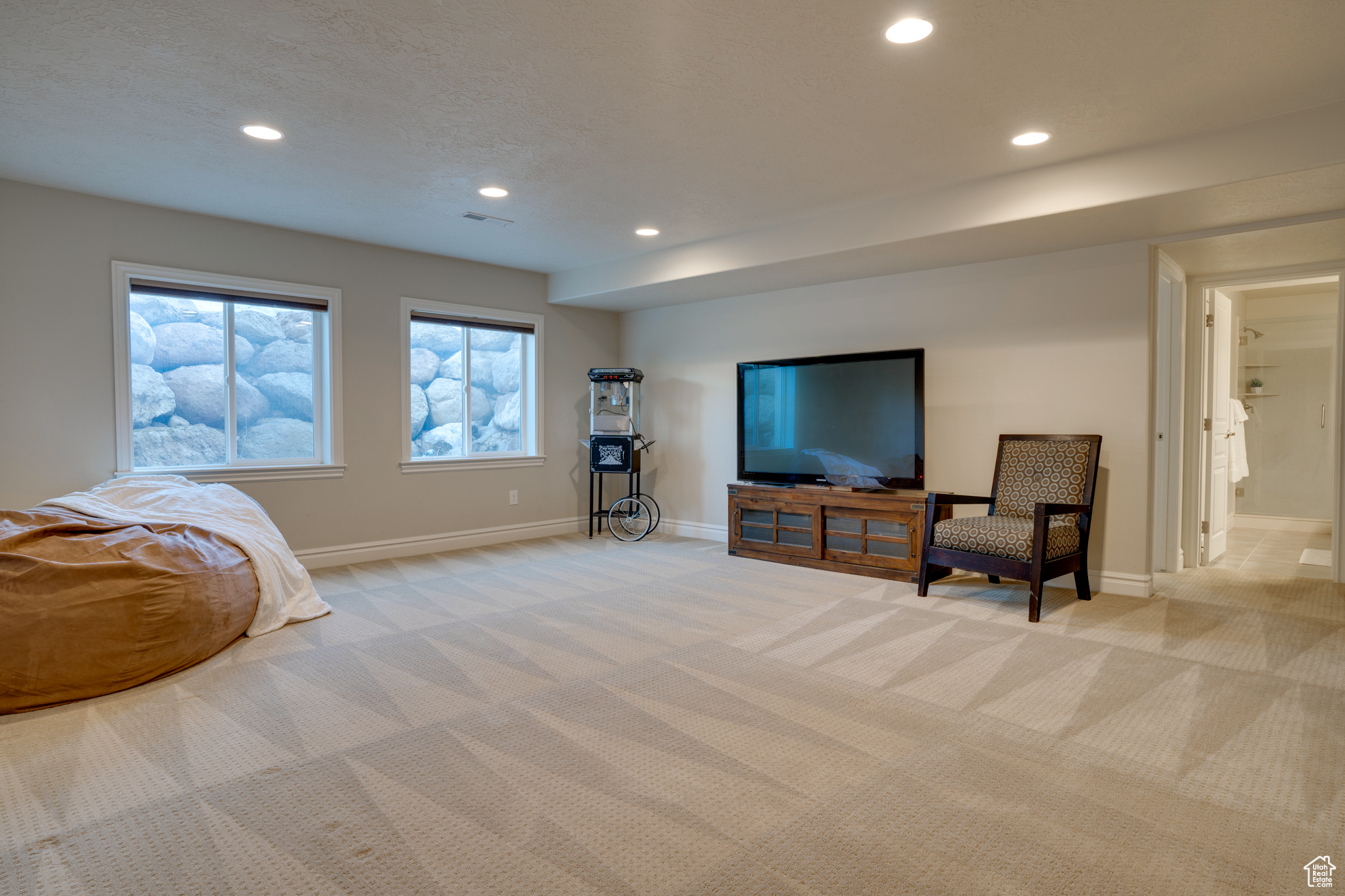 Living area with light colored carpet and a textured ceiling