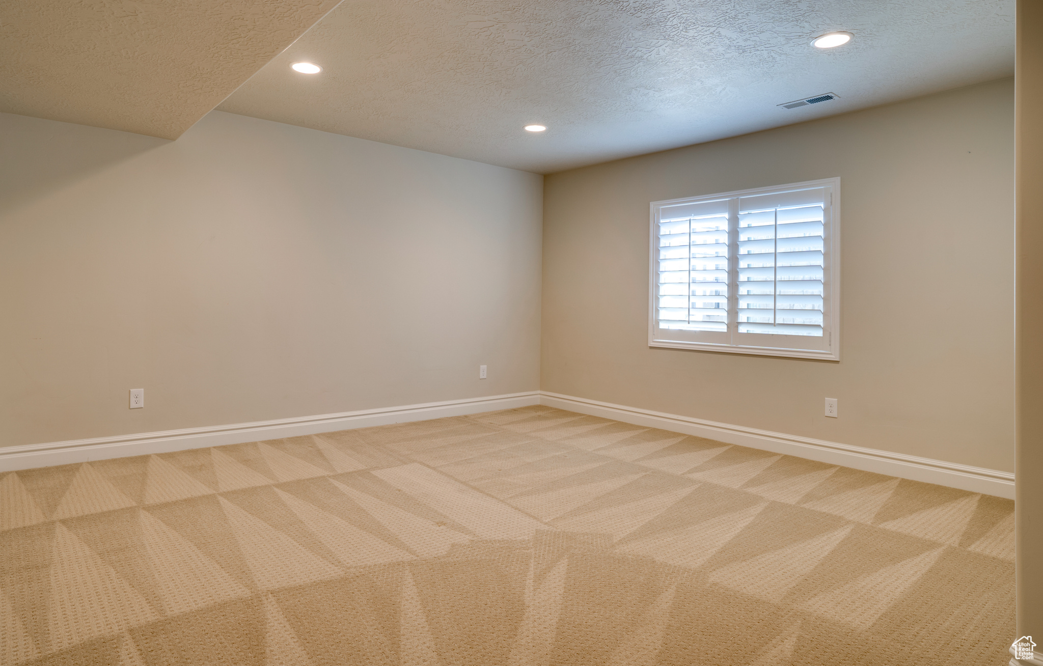 Carpeted empty room with a textured ceiling