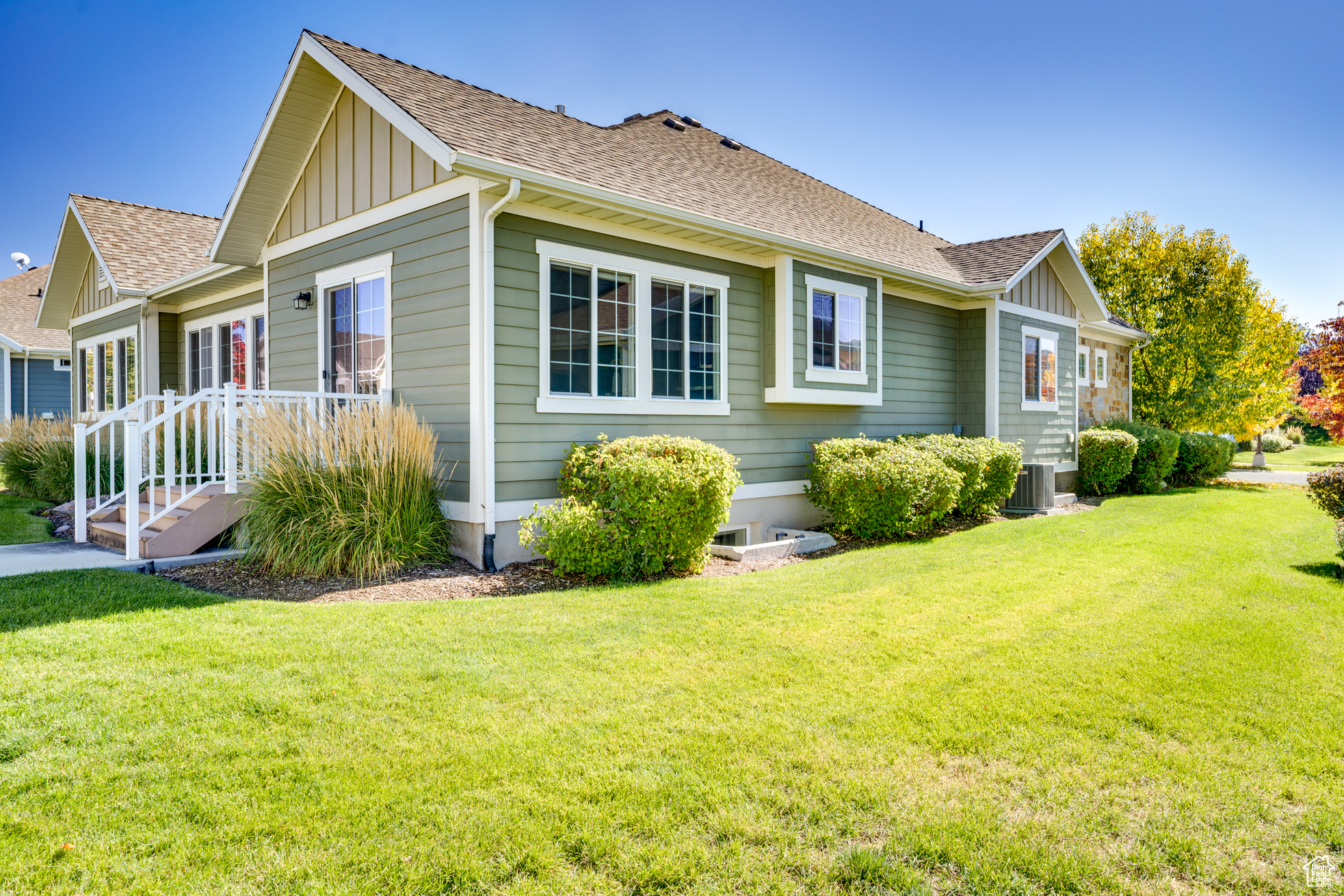 View of side of property featuring central AC and a lawn