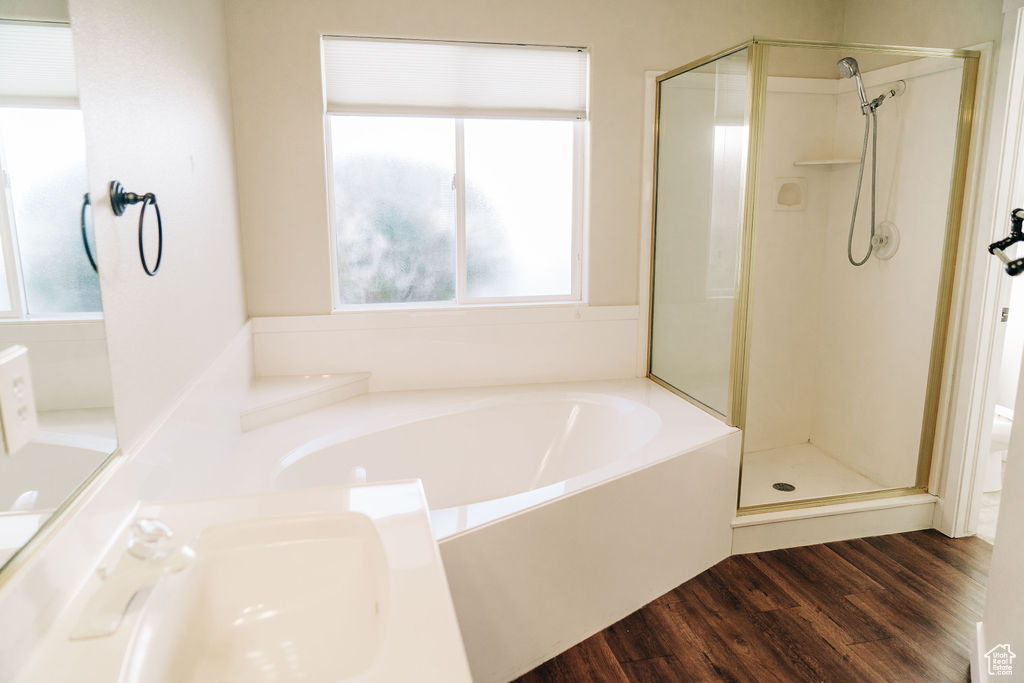 Bathroom with independent shower and bath, sink, and hardwood / wood-style floors