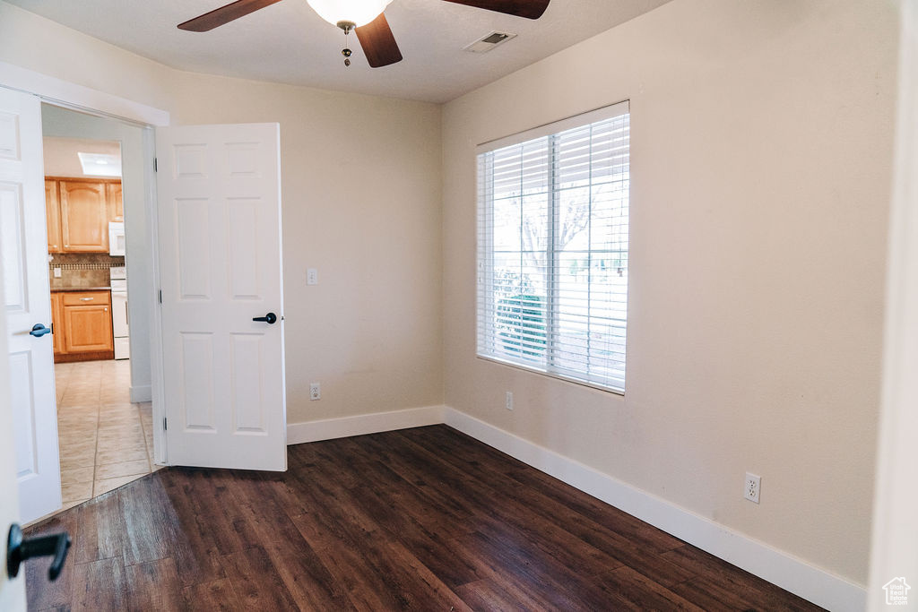 Spare room featuring ceiling fan and dark hardwood / wood-style flooring