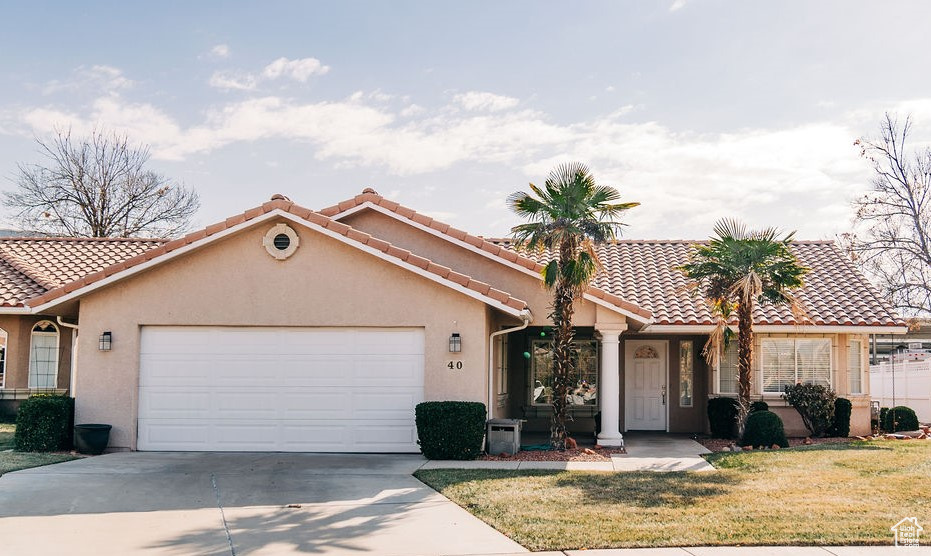 View of front of property featuring a garage and a front yard