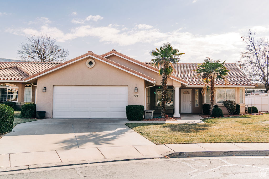 View of front of house with a garage and a front lawn