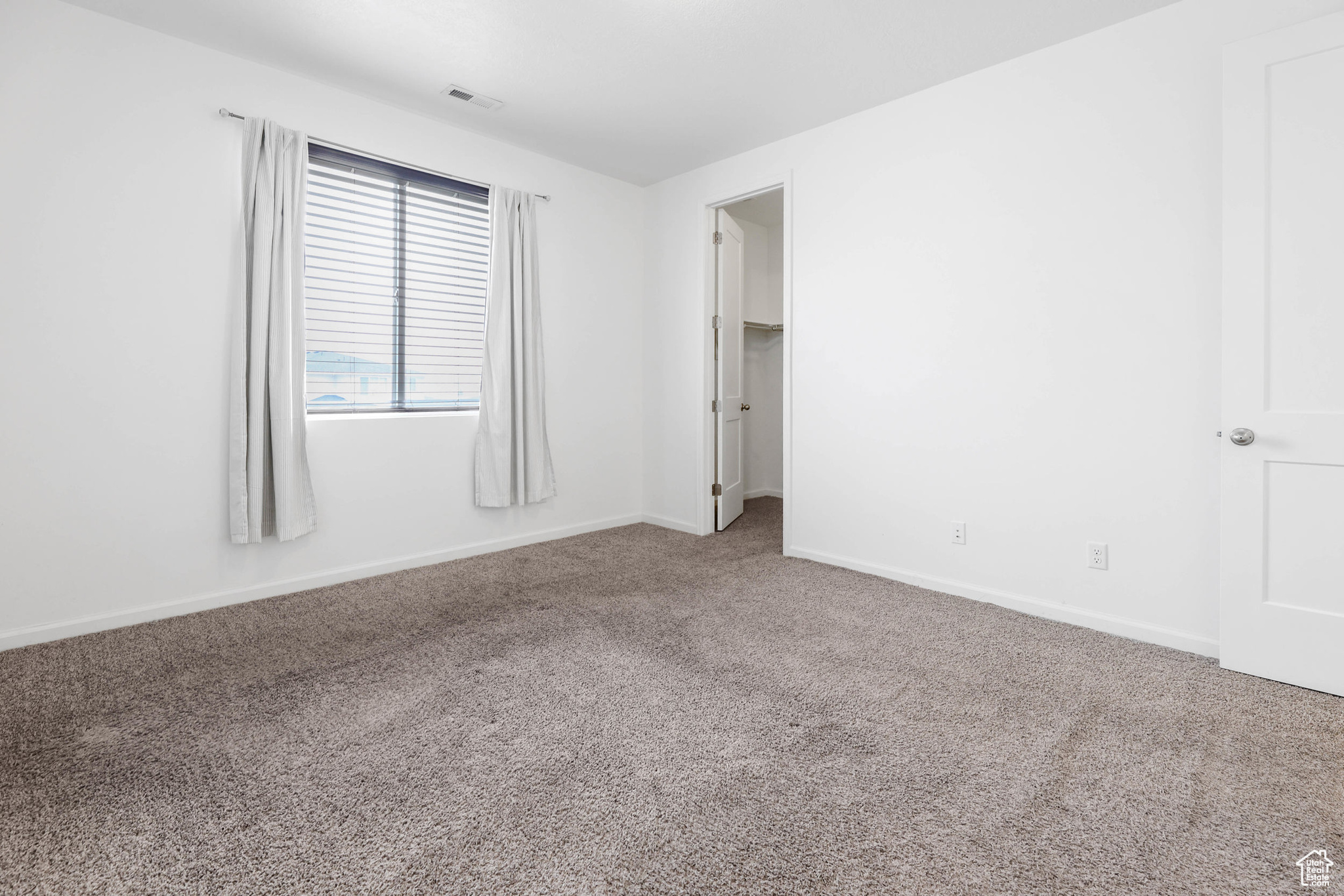 View of unfurnished carpeted primary bedroom