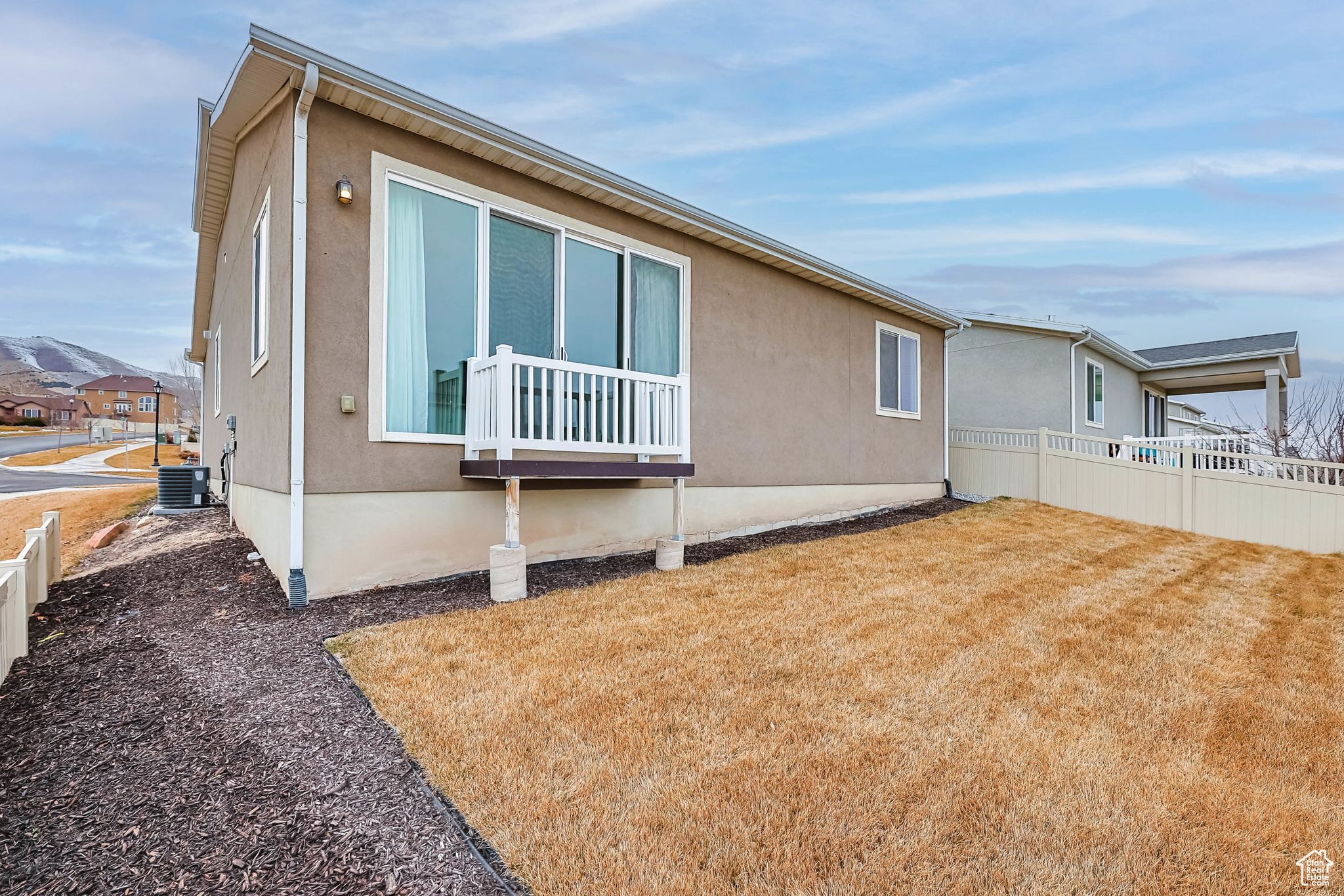 View of side of property with central AC and a lawn