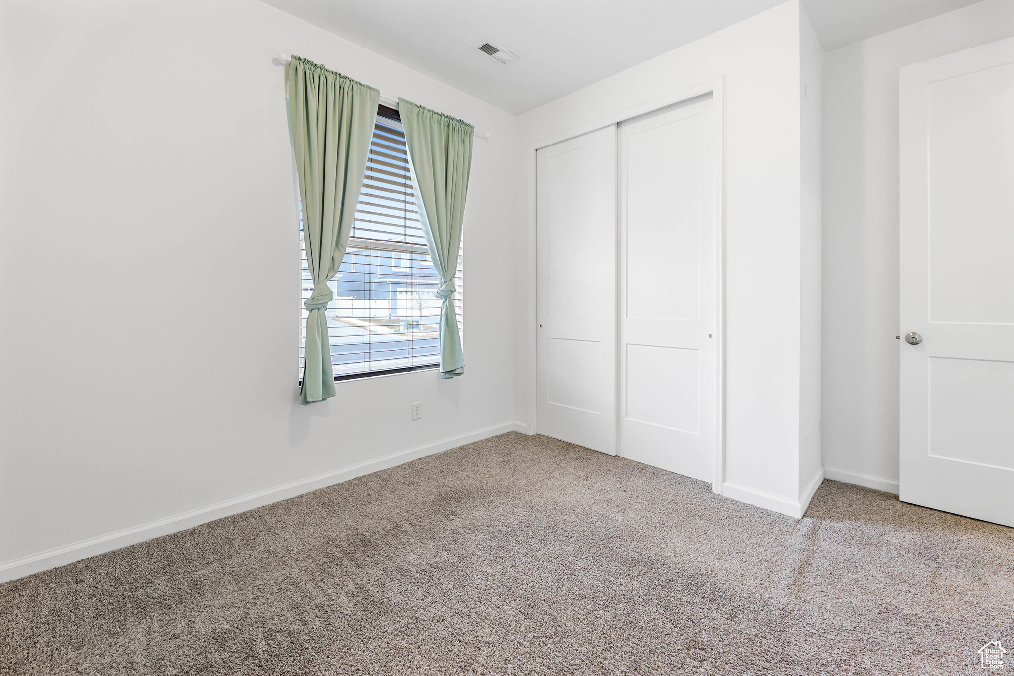 Unfurnished bedroom featuring carpet floors and a closet