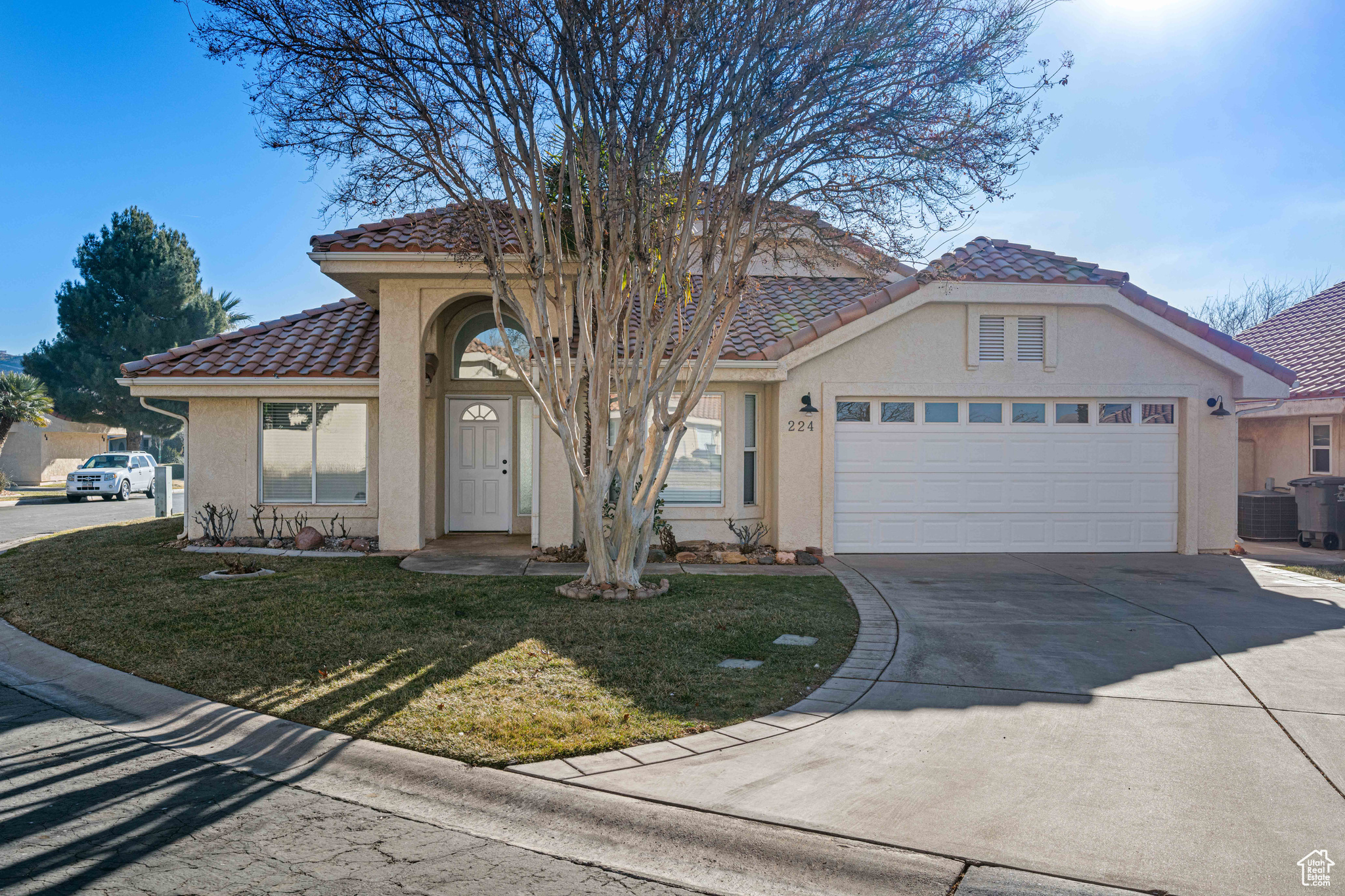 View of front facade featuring cooling unit, a garage, and a front yard