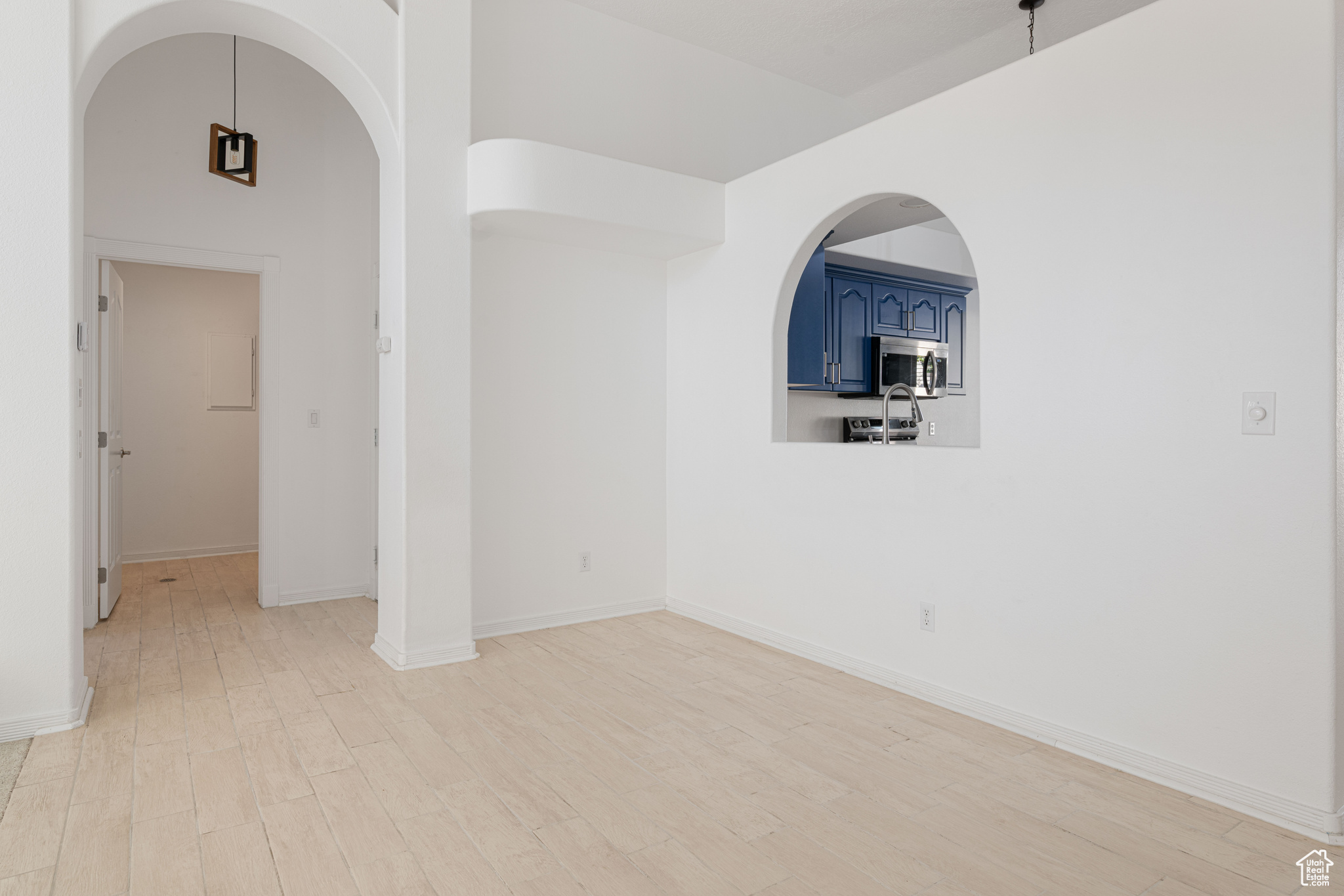 Unfurnished room featuring a towering ceiling and light hardwood / wood-style floors