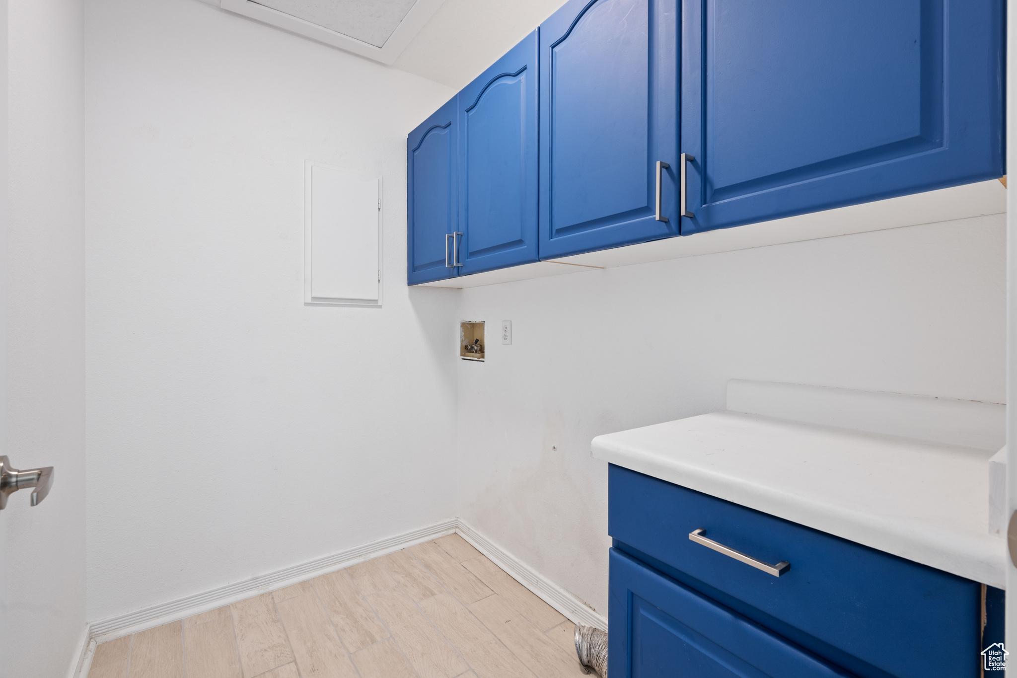 Laundry area with washer hookup, cabinets, and light wood-type flooring