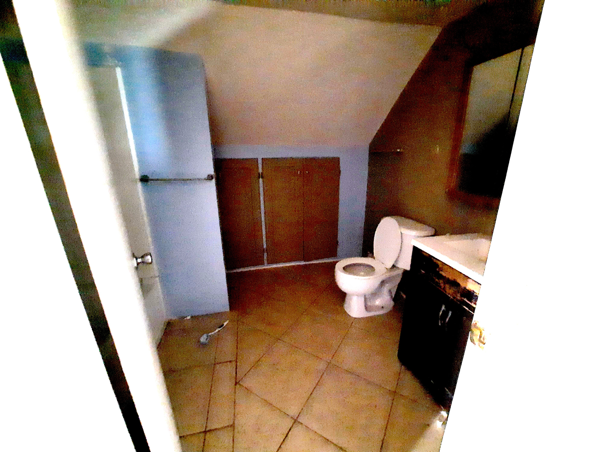 Bathroom with vaulted ceiling, vanity, toilet, and tile patterned flooring