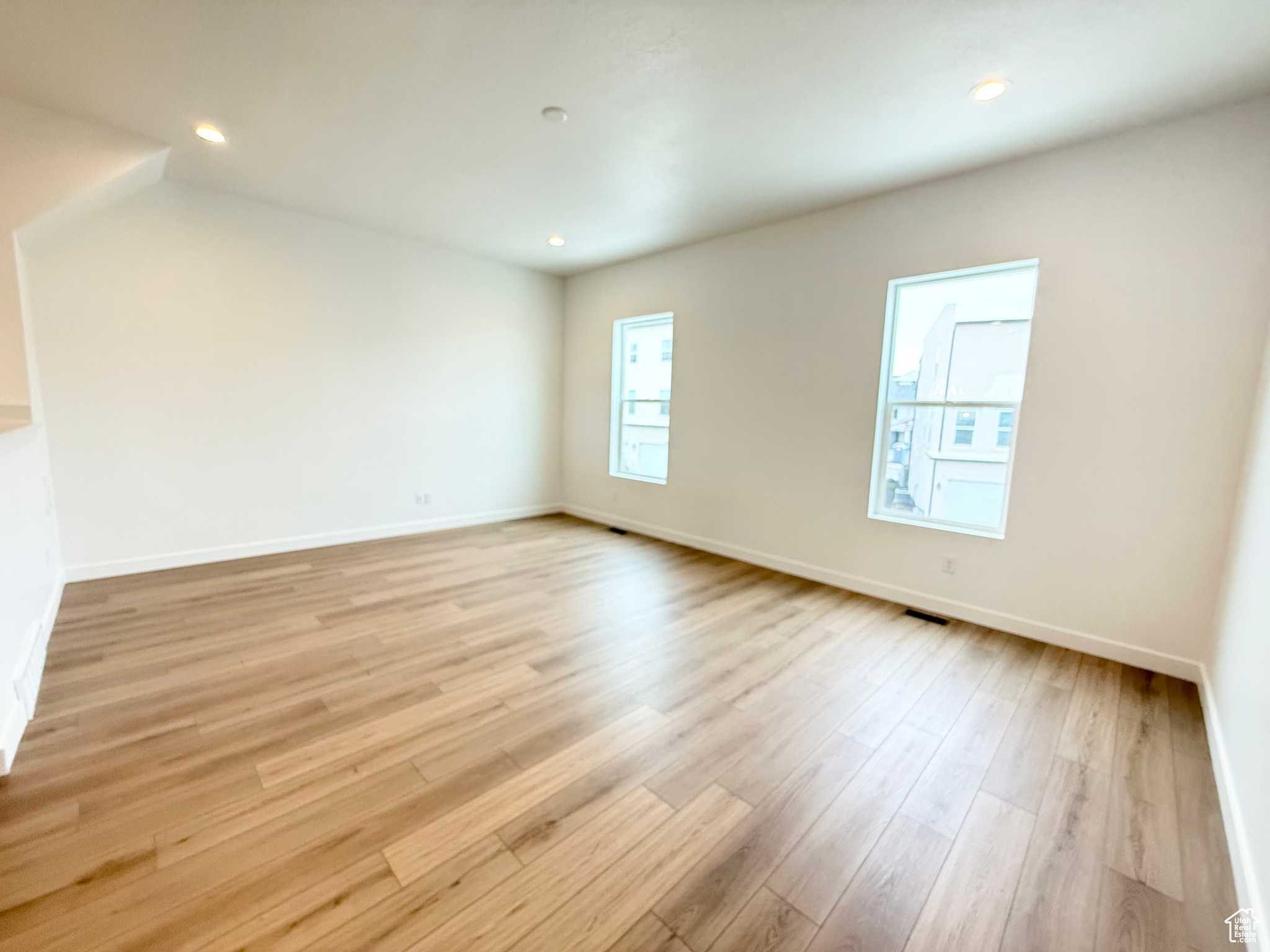 Empty room with light hardwood / wood-style flooring